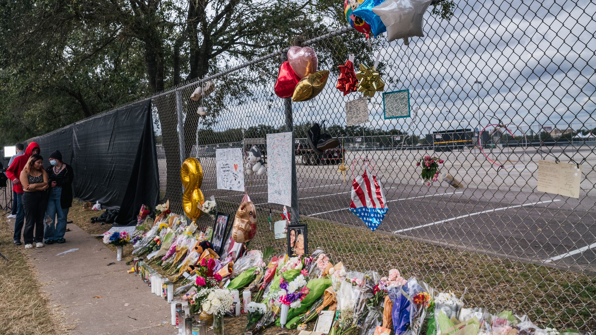 People look at a memorial to those who died at the Astroworld festival