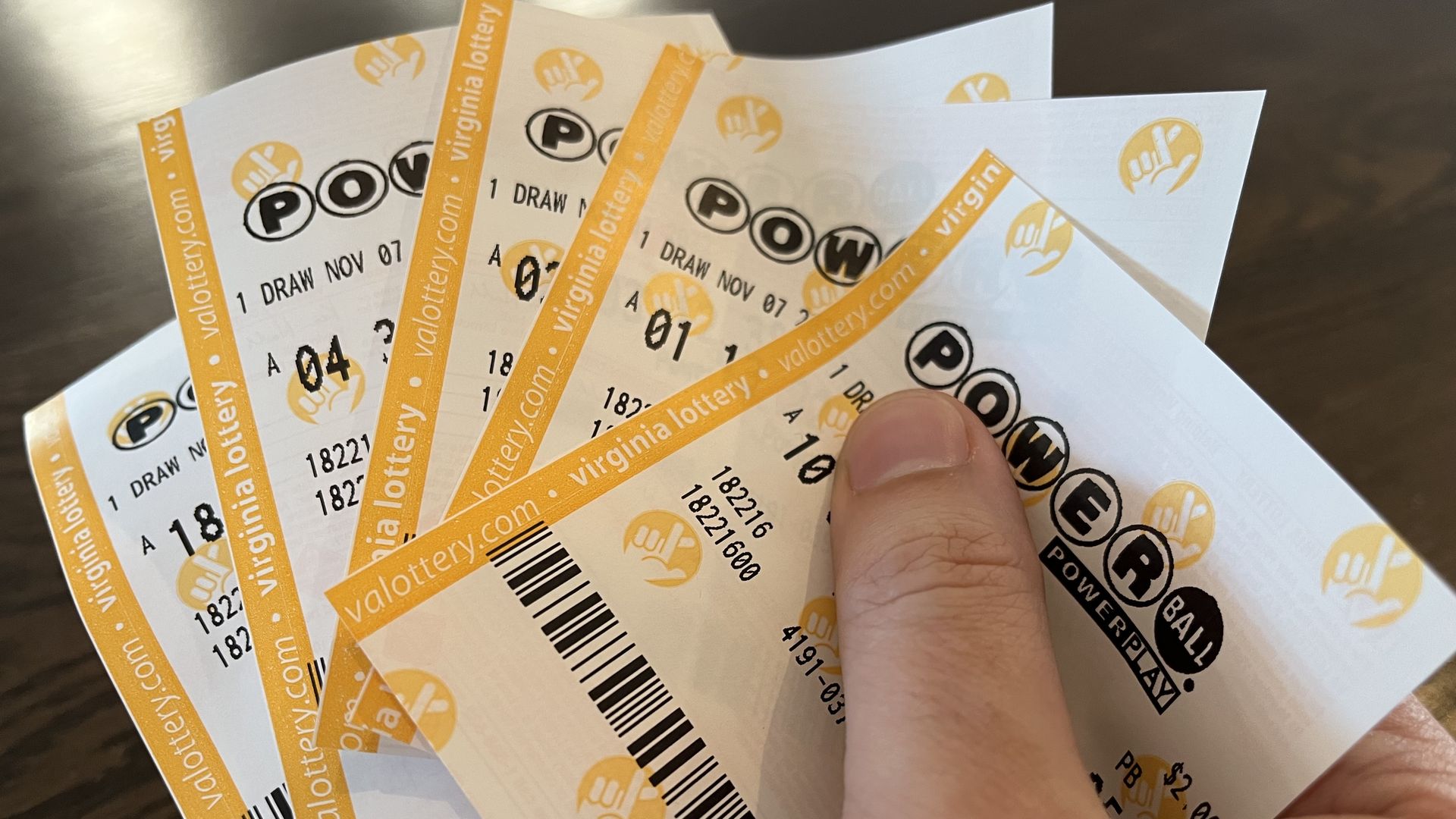 Hand holding Powerball tickets