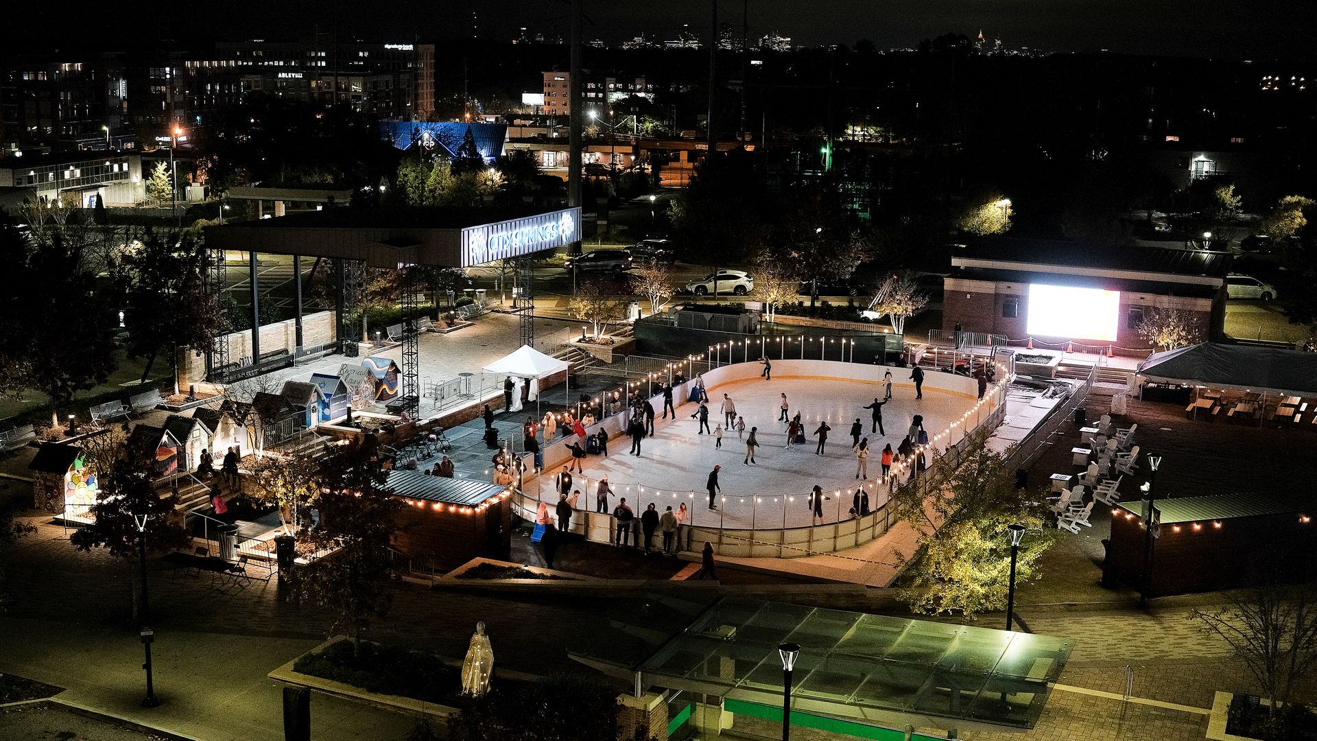 A nighttime photo of people ice skating on an outdoor rink