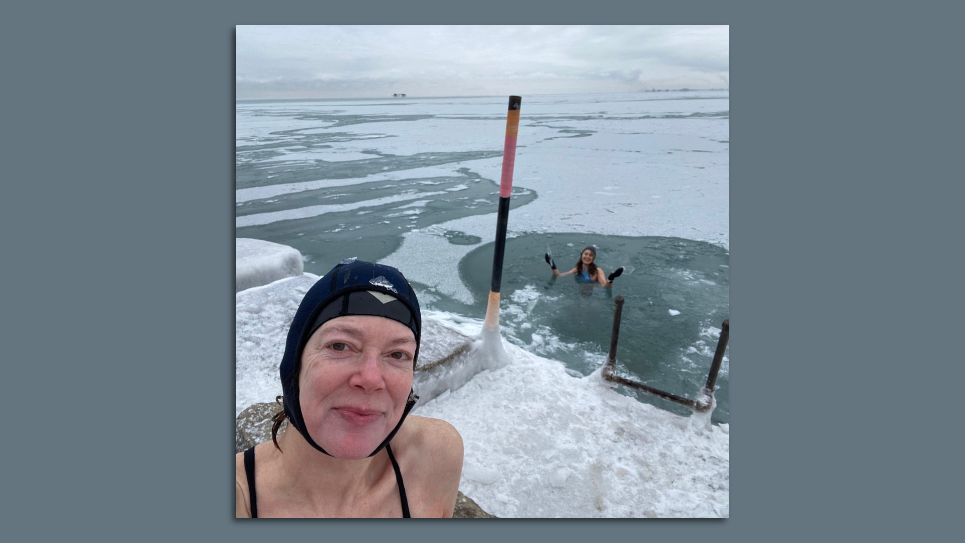 Photo of a woman in a swim cap getting ready to swim in icy waters