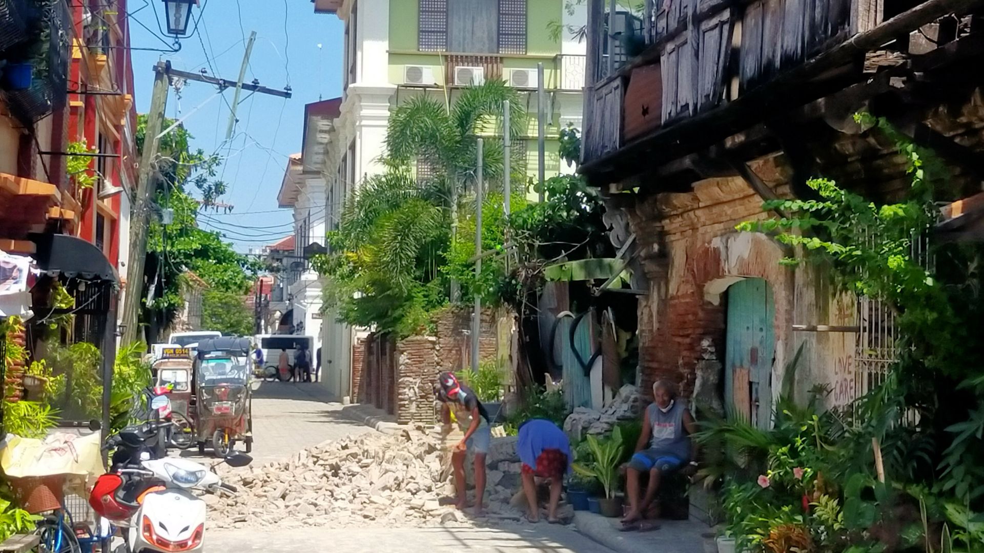 Residents try to clear up debris from an old house in Vigan city, Ilocos Sur province north of Manila on July 27.