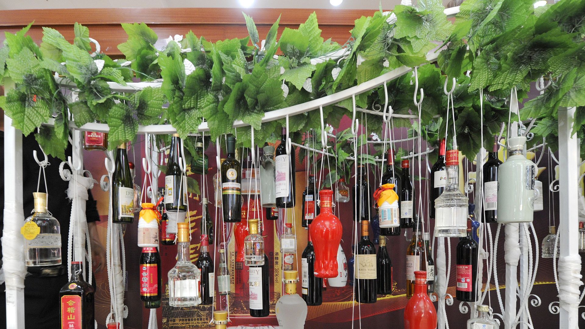 Liquor bottles hanging from strings outside a store