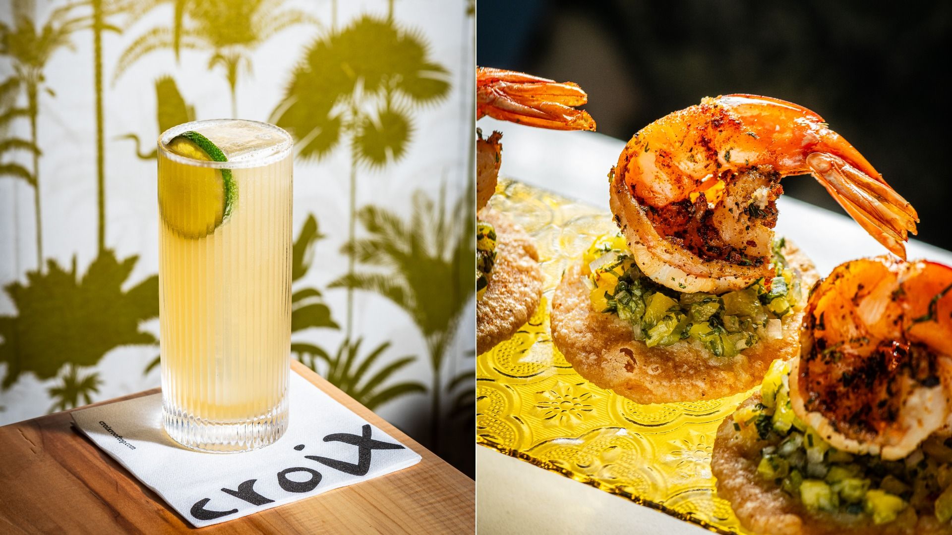 Split image: left a tall pale-yellow cocktail with a lime wedge, set on a wooden table against a palm-pattern backdrop; right a close-up of a shrimp-topped savory pastry with diced vegetables on a gold platter.