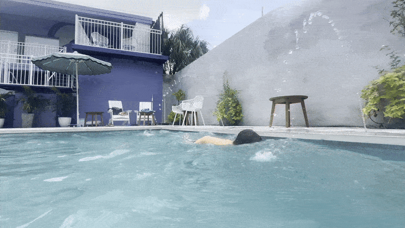 Image shows a child swimming in a pool.