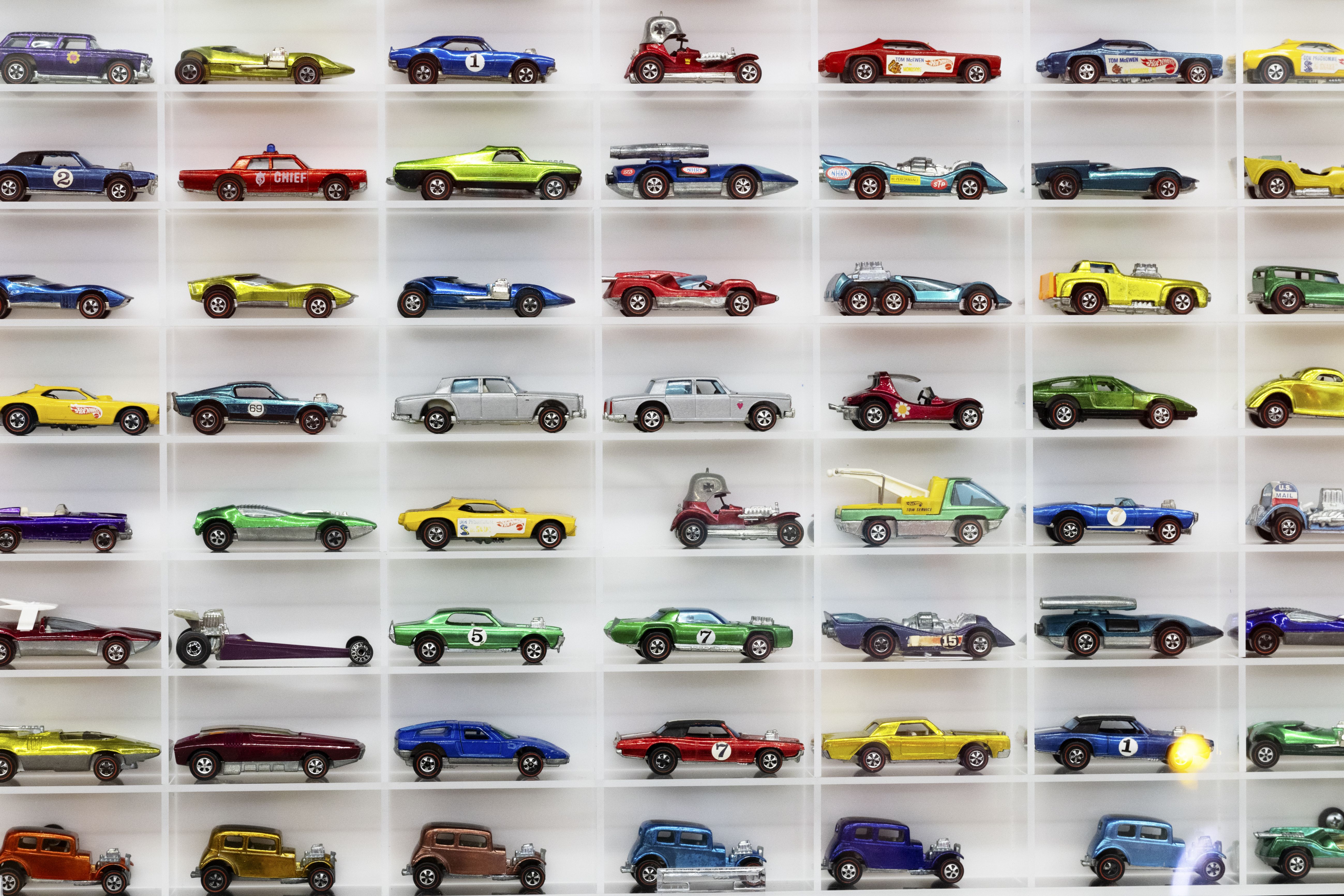 A display shelf showing rows and rows of toy cars in different designs and colors