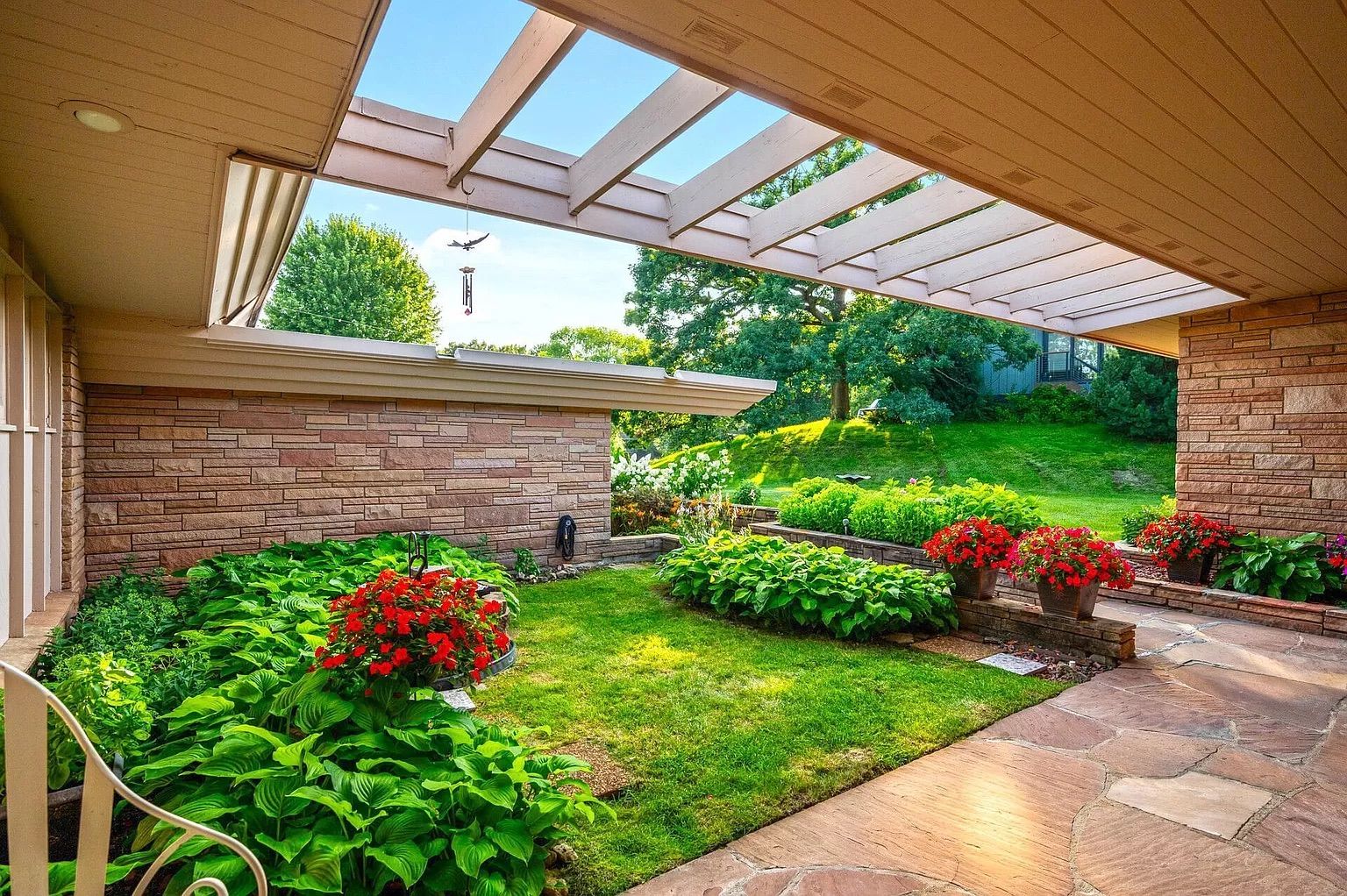 A terrace with a grassy area and lush landscaping.