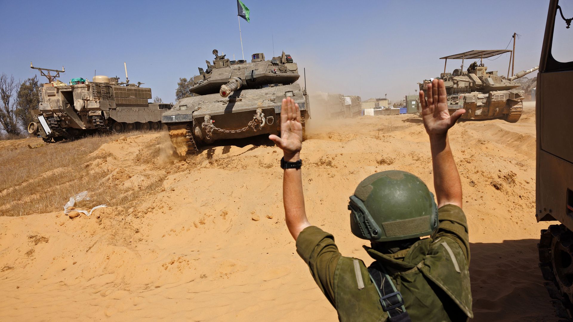 Soldier directs Israeli tanks near a border crossing to the southern Gaza strip