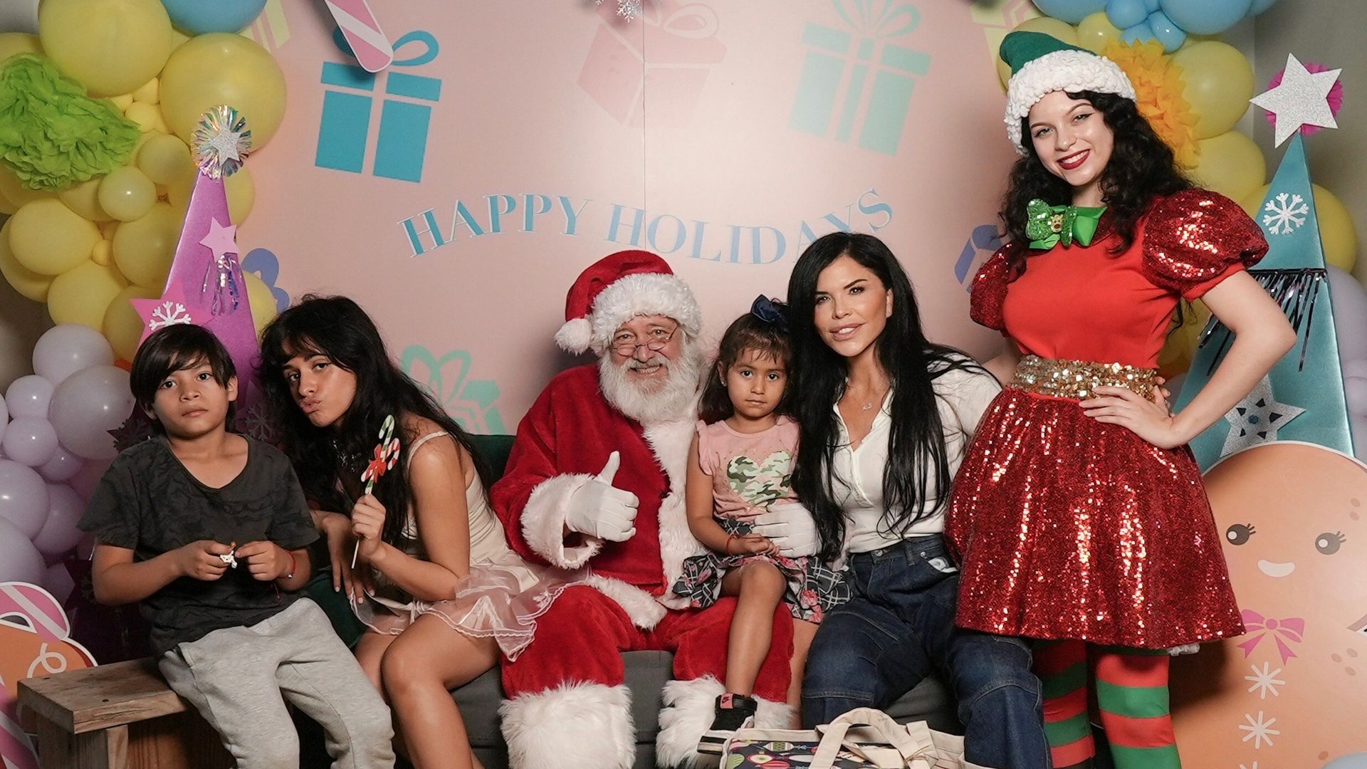 A group of adults and children gather with Santa