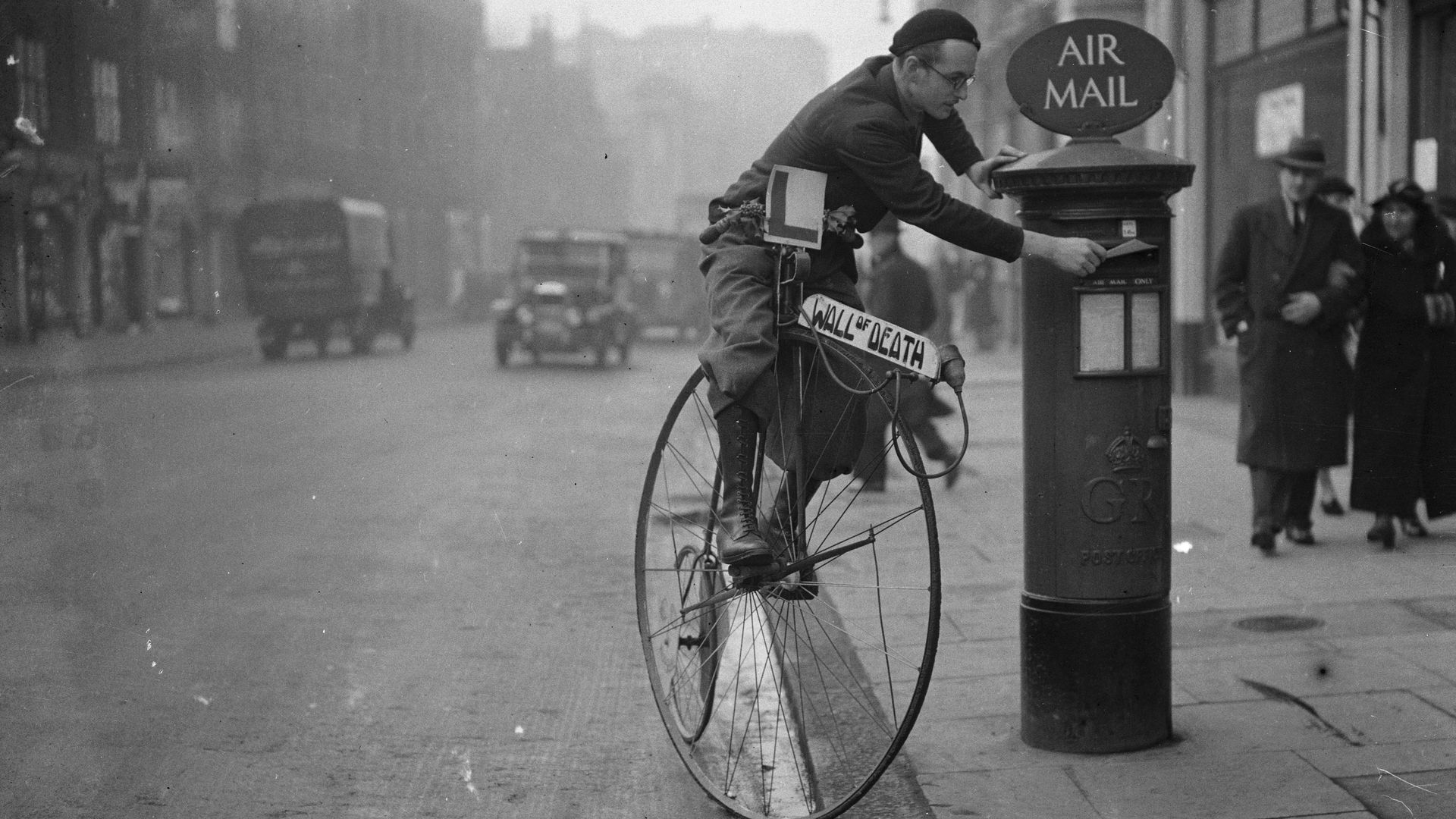 Man on bicycle at mailbox