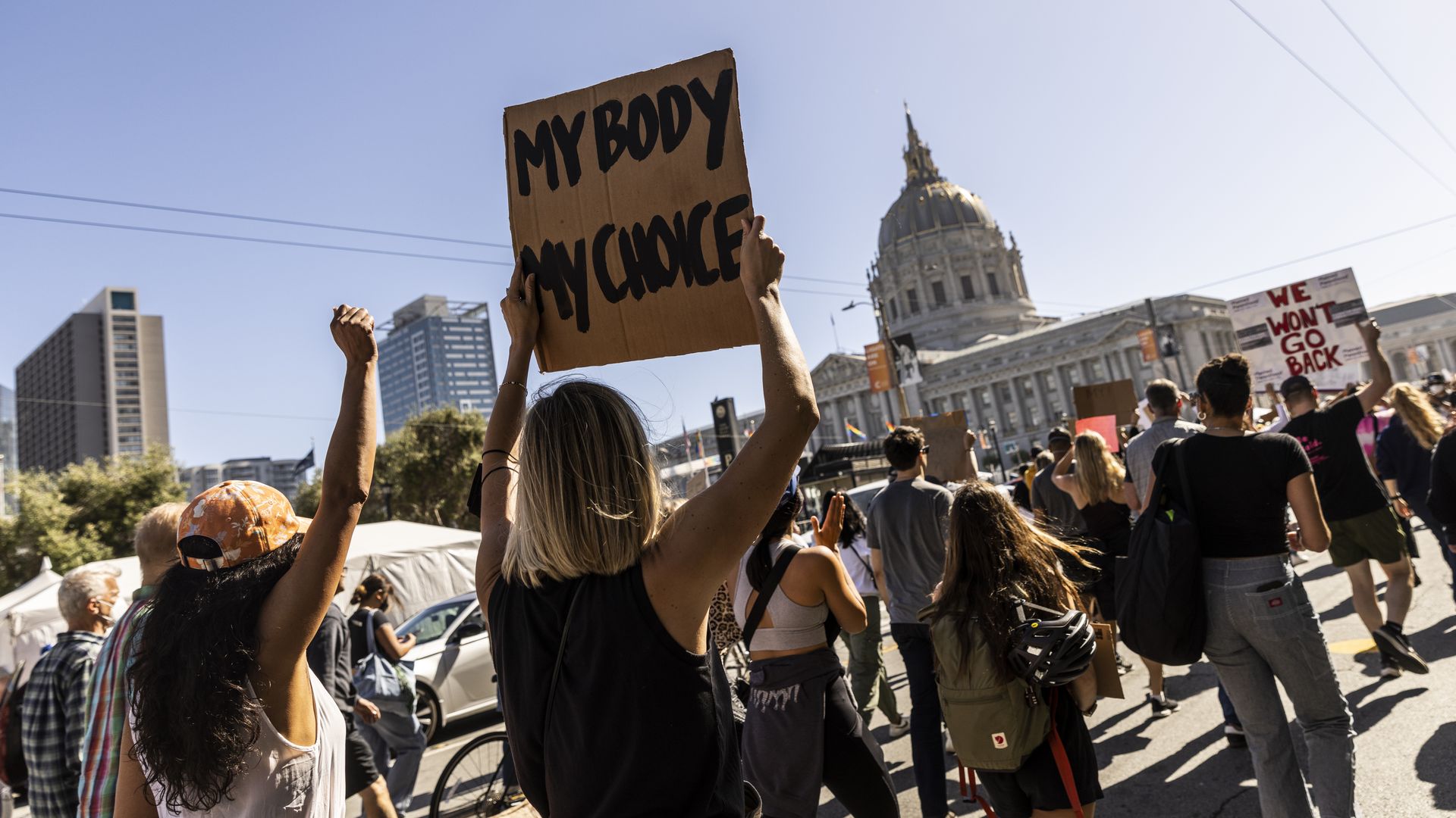 Photo of pro-abortion advocates holding signs and marching toward the SF City Hall