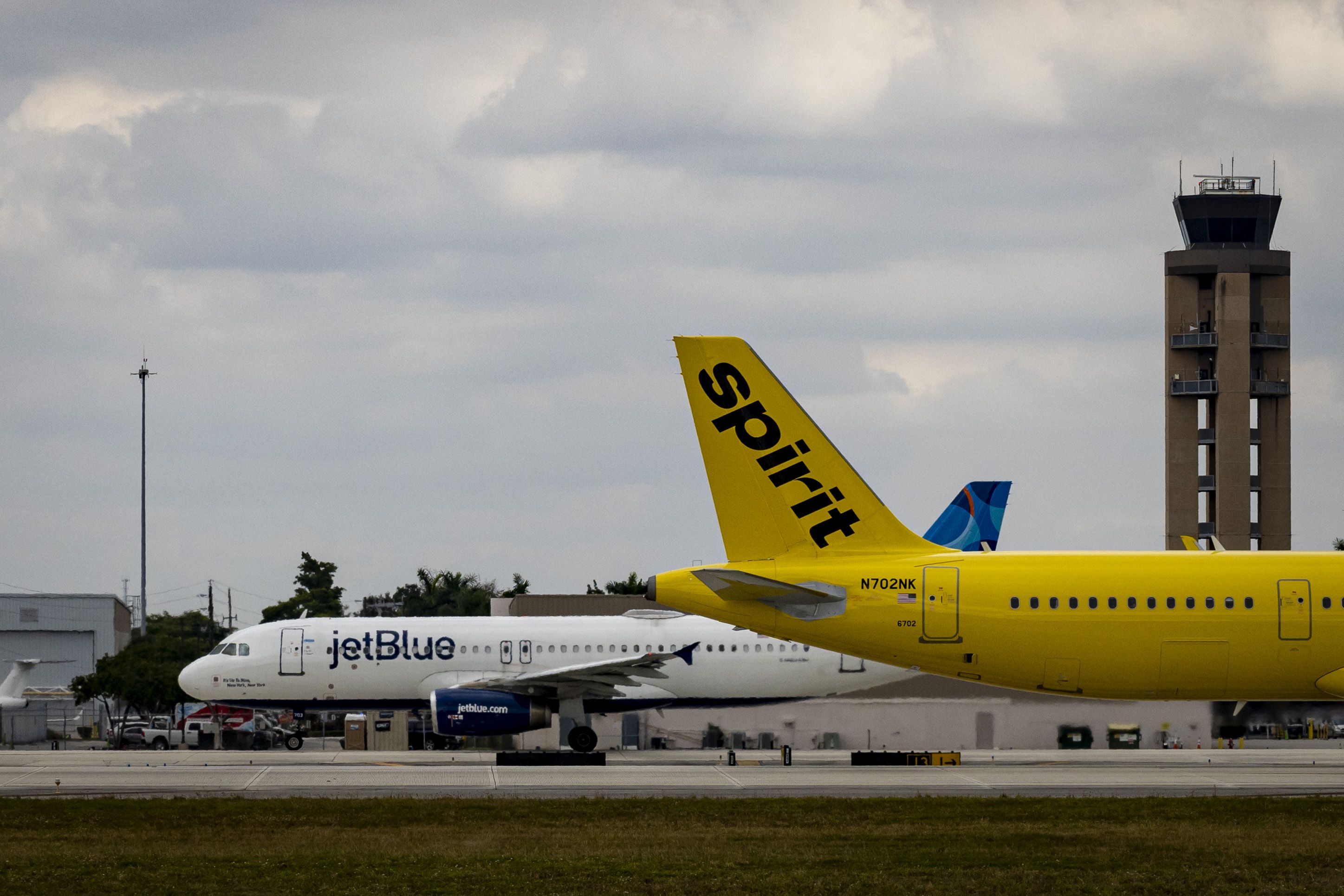 Spirit and JetBlue planes at Fort Lauderdale-Hollywood International Airport (FLL) in Fort Lauderdale, Florida, US, on Wednesday, Nov. 1, 2023. The US crackdown on airline consolidation faces a new test this week with the trial of a government lawsuit claiming the $3.8 billion takeover of Spirit Airlines Inc. by JetBlue Airways Corp. would reduce competition and boost fares for passengers. Photographer: Eva Marie Uzcategui/Bloomberg via Getty Images