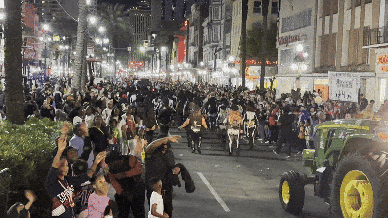 Image shows people dressed as skeletons in a parade.