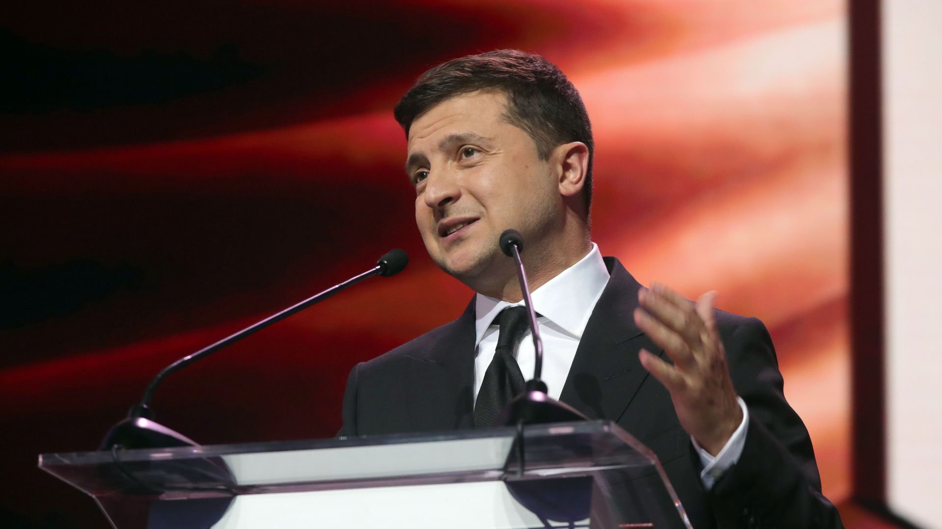 Photo of Volodymyr Zelenskyy speaking from a podium and gesturing with one hand