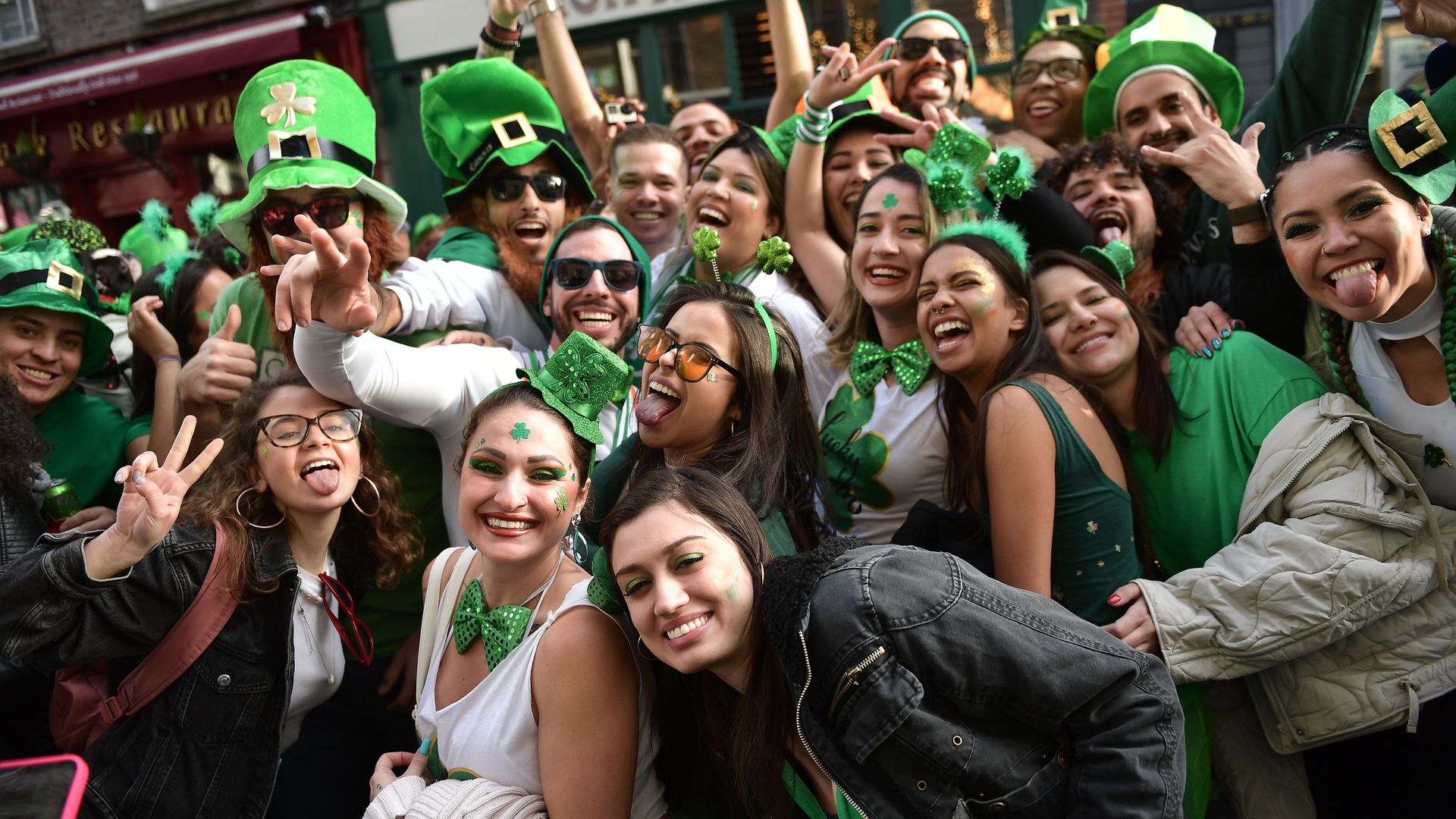 A group of friends dresses in St. Patrick's Day outfits pose for a photo.