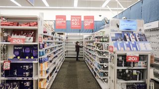 An aisle of a store with sale signs suspended from the ceiling