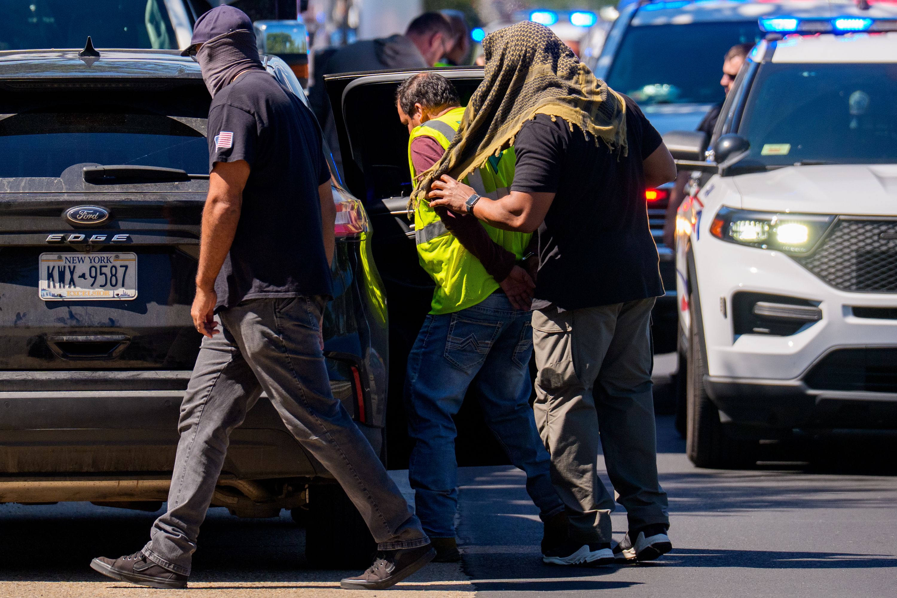 A driver is detained at a traffic safety checkpoint conducted by the Department of Homeland Security and the Washington Metropolitan Police Department along New York Avenue Northeast on September 8, 2025 in Washington, DC.