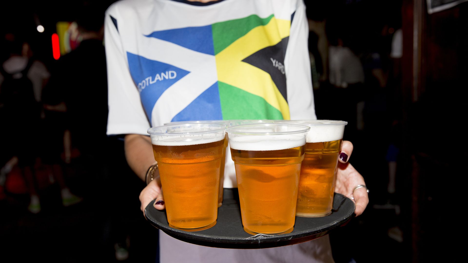 Beer in clear plastic cups on a serving tray