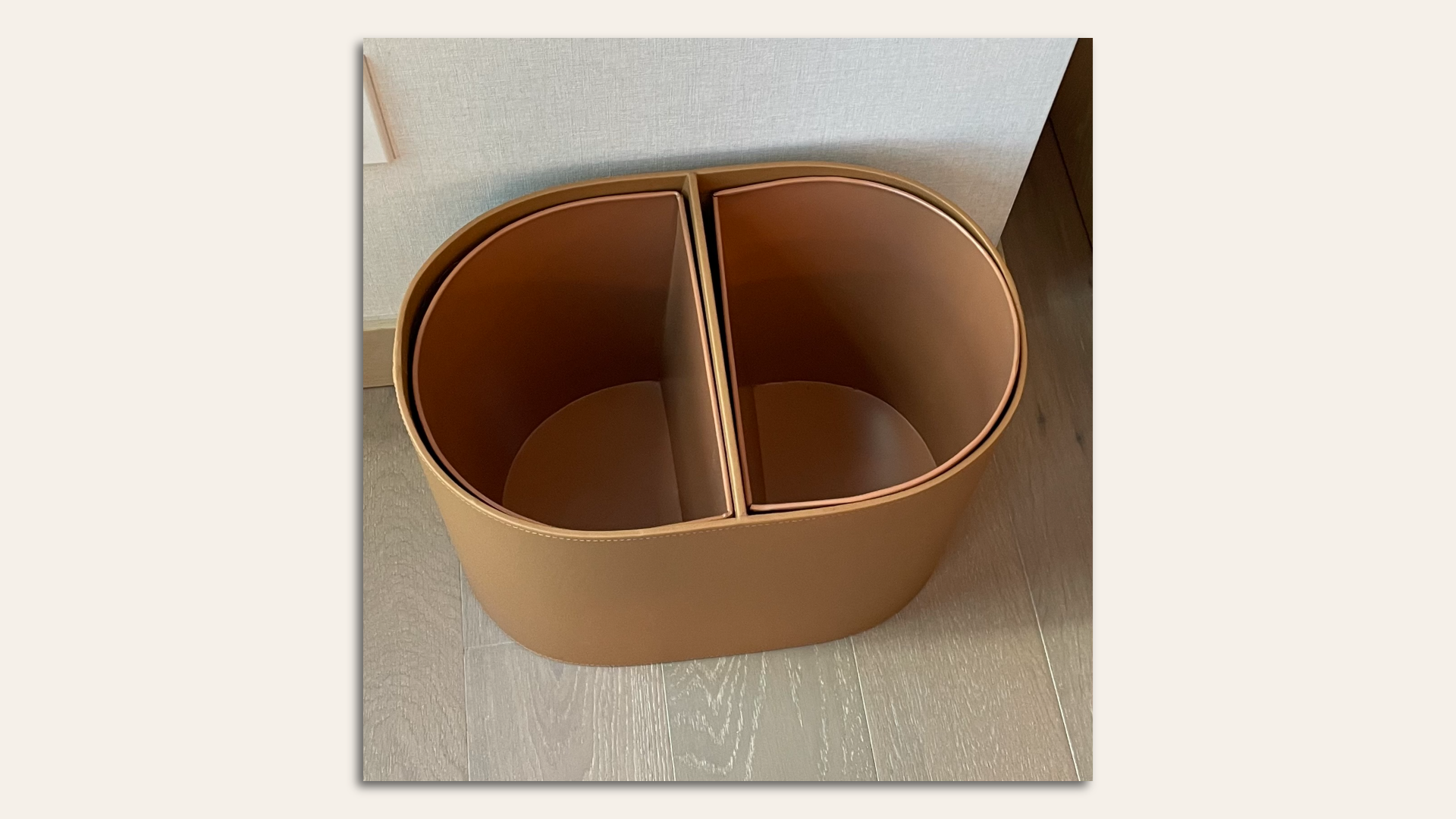 A hotel room wastebasket with one side for recycling.