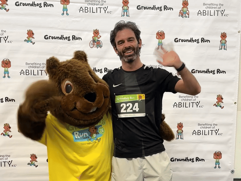 A gopher mascot and reporter Travis Meier wave at the camera in a gif at the Groundhog Run benefiting the children of Ability KC.