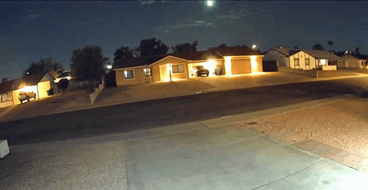 A meteor explodes in a night sky.