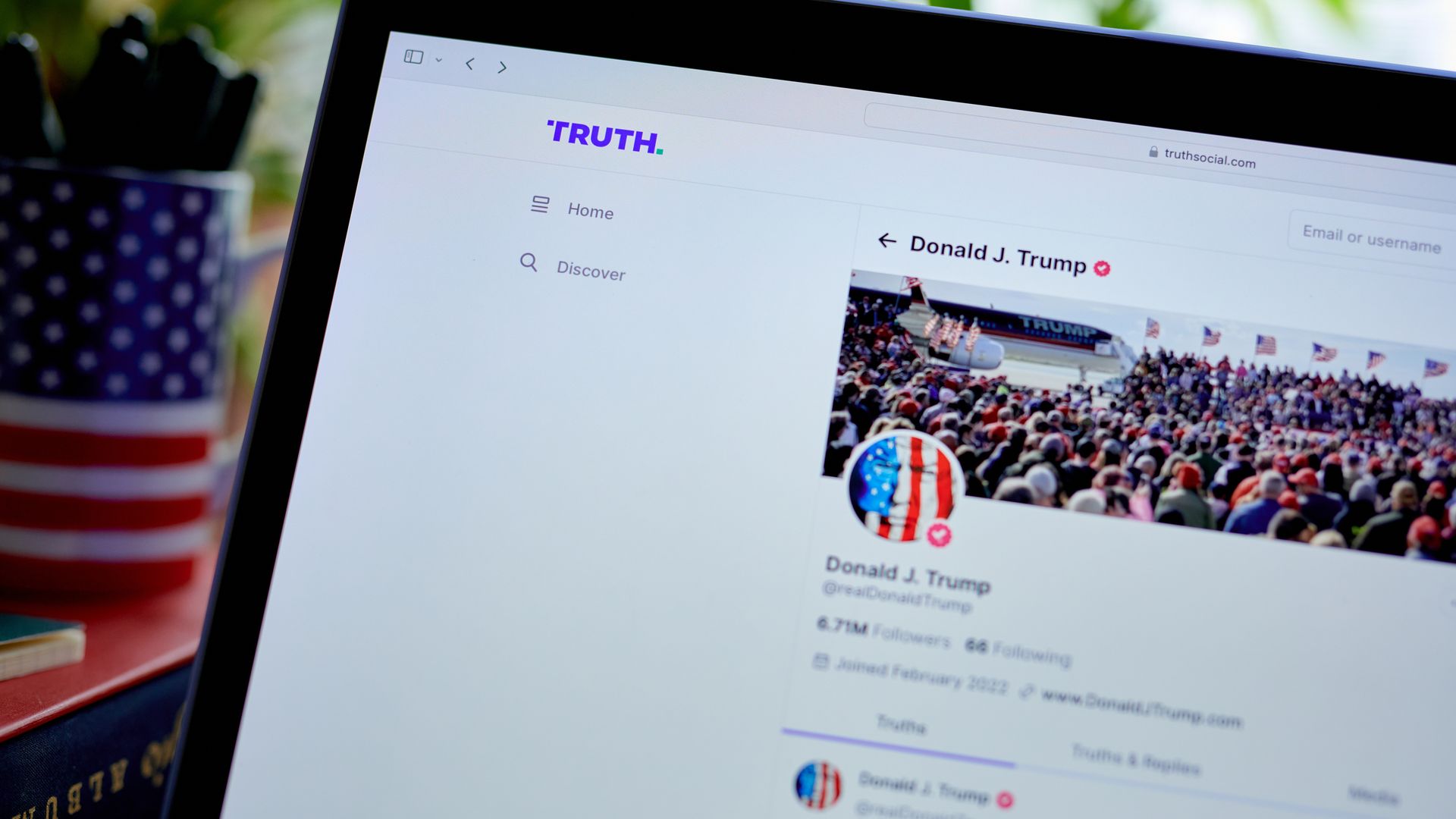 A laptop open to the Truth Social website with Donald Trump's profile