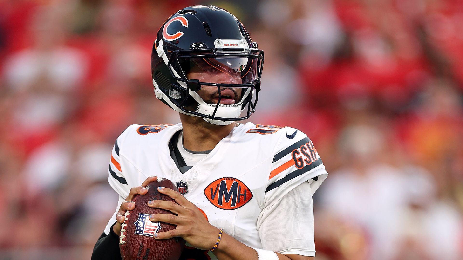 Photo of a football player with a ball in his hands, ready to throw. 