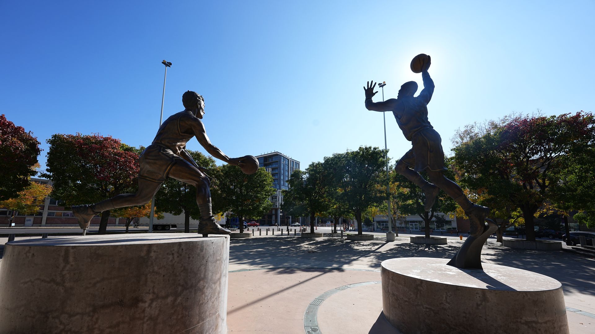 Statues of basketball players in a city plaza.