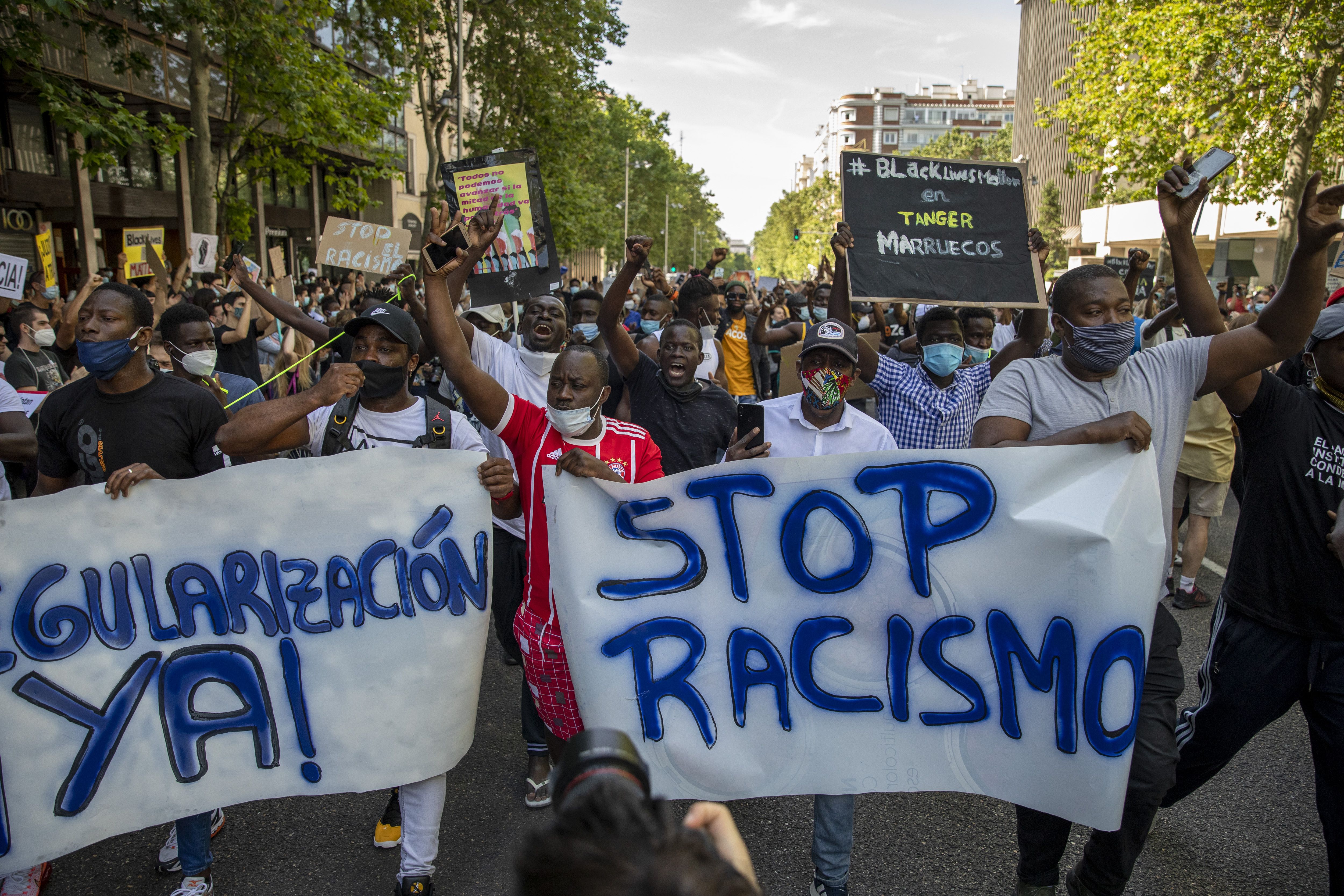 Demonstrators shout slogans during a Black Lives Matter protest following the death of George Floyd as a banner reads 'Stop Racism' outside the United States Embassy on June 07, 2020 in Madrid, Spain.