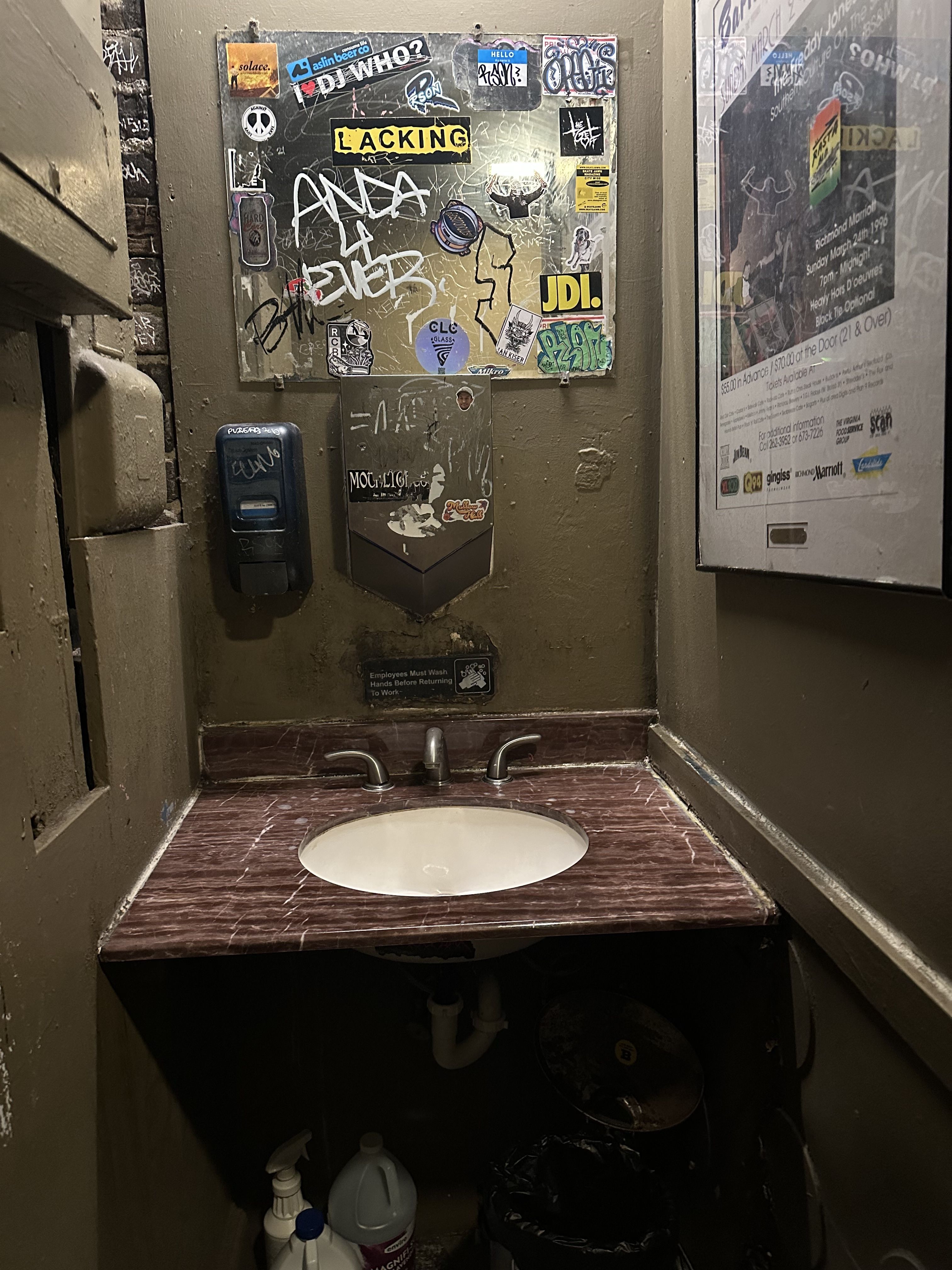 A disgusting looking bathroom sink covered in graffiti  