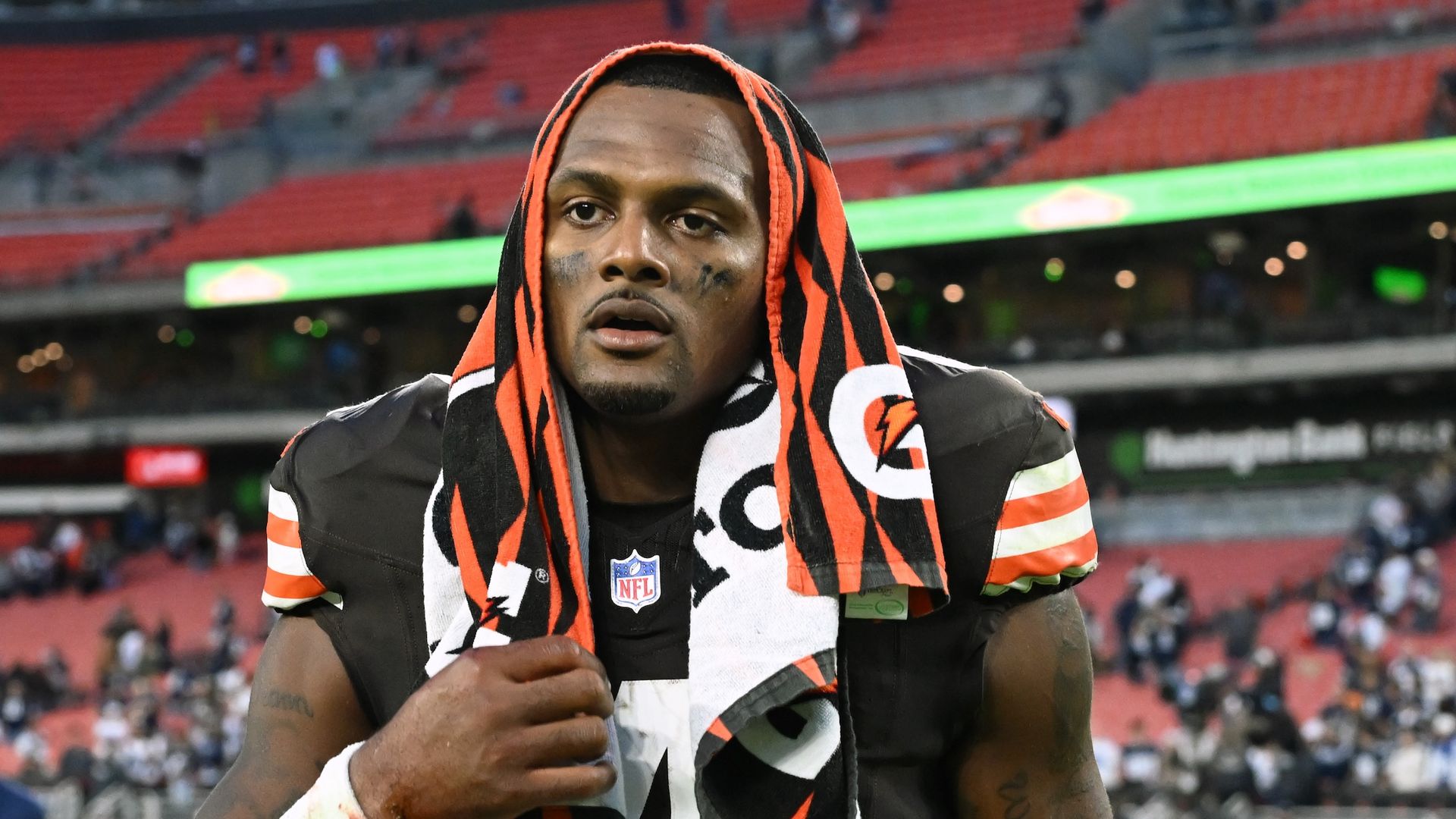 Browns quarterback Deshaun Watson walks off the field with towel on his head. 