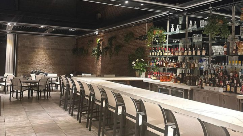 A long bar counter and tables in the MIA Lounge at Umbria in the North End.