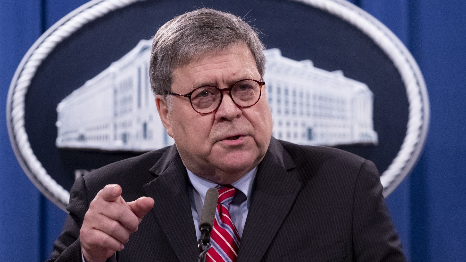 Photo of Bill Barr speaking while raising a finger