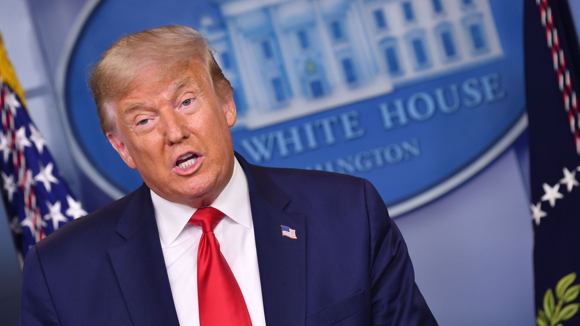 Trump speaking in front of the White House sign 