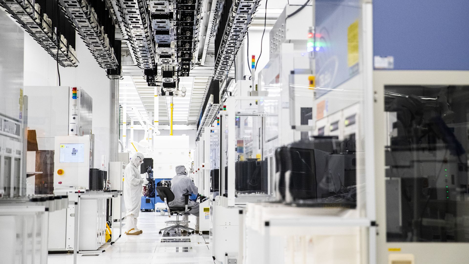 Employees wearing cleanroom suits monitor chemical vapor deposition operations inside the GlobalFoundries semiconductor manufacturing facility in Malta, New York, U.S., on March 16, 2021.