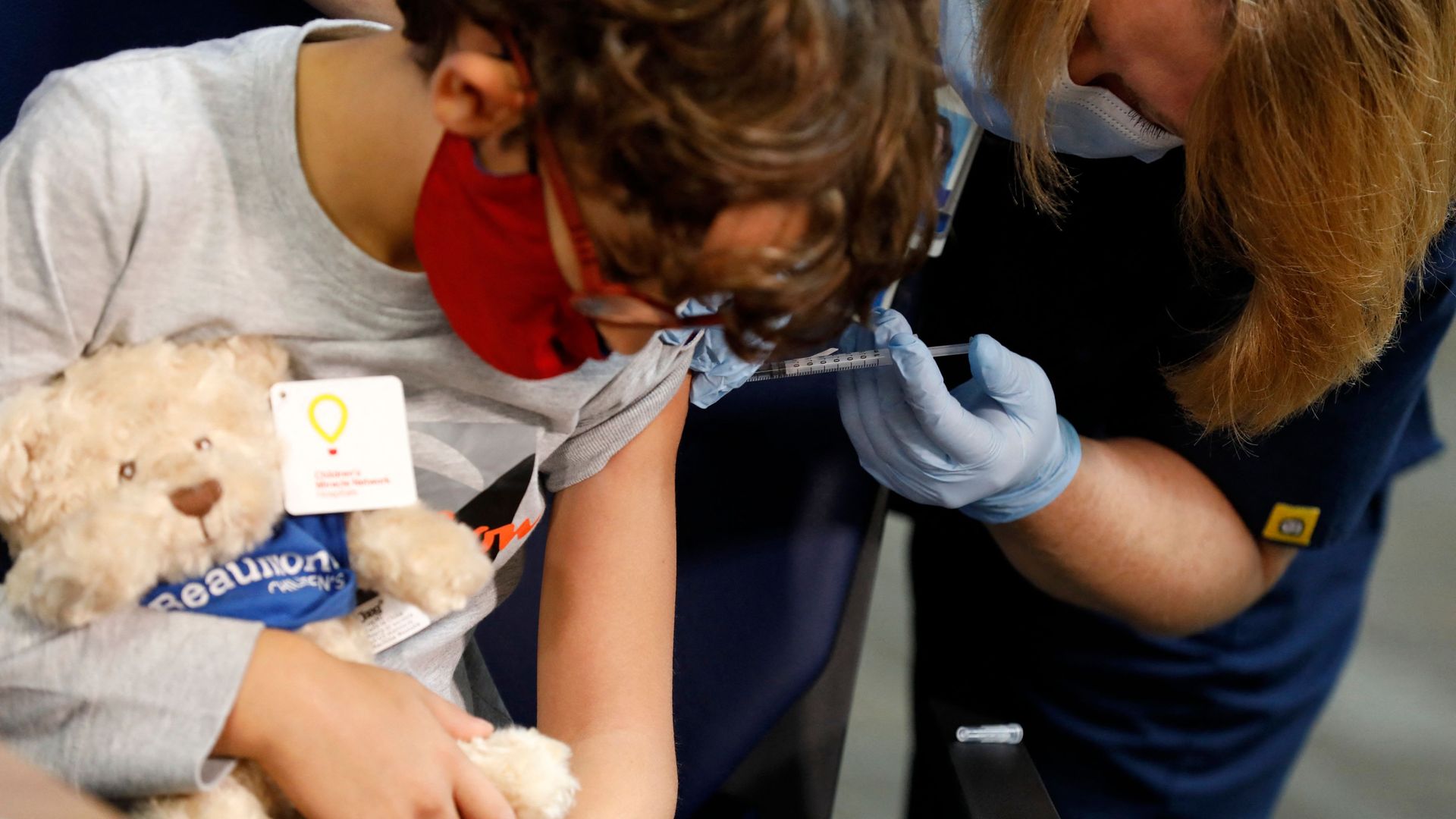 A 7 year-old child receives their first dose of the Pfizer Covid-19 vaccine at the Beaumont Health offices in Southfield, Michigan.