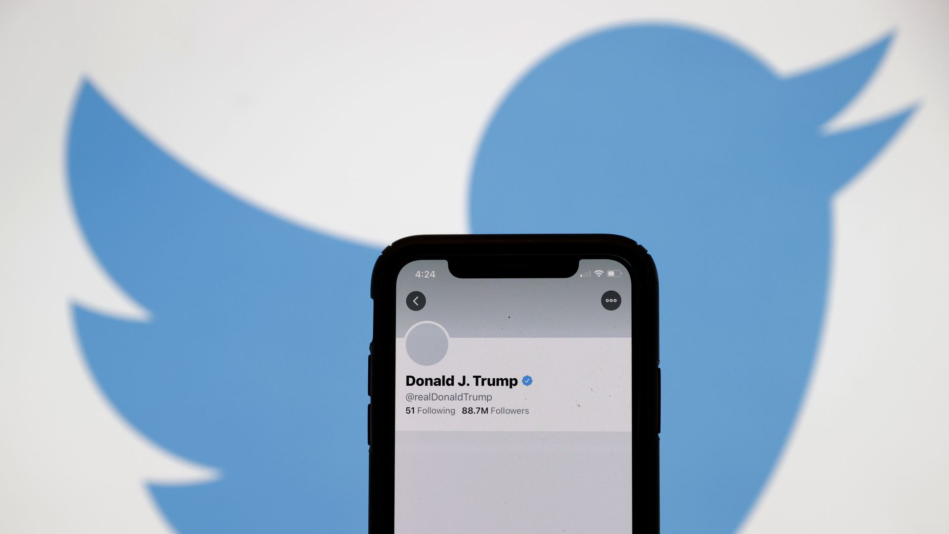 A smartphone is seen in front of the Twitter logo after President Trump was banned from the app.