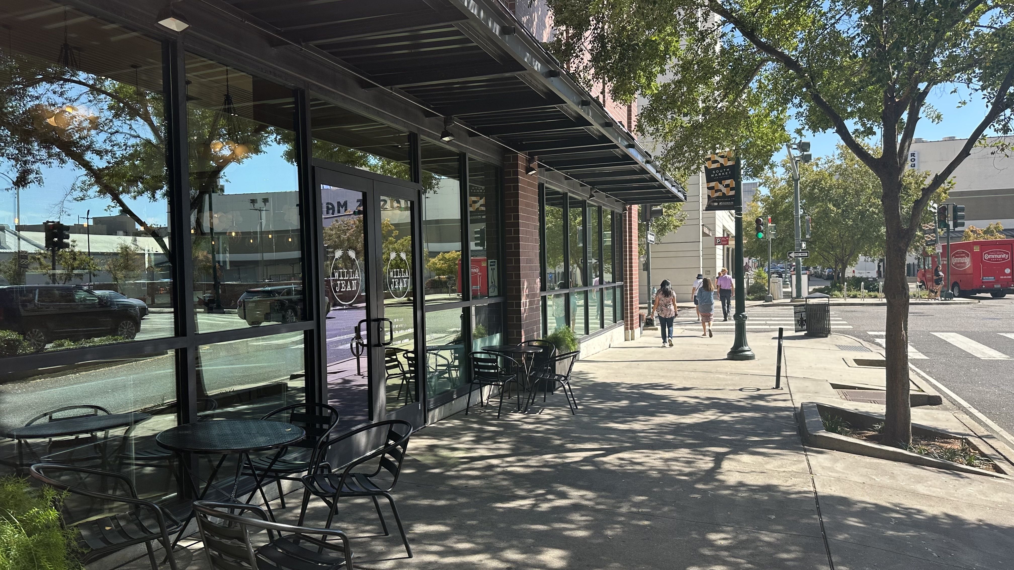 An exterior photo of a restaurant with glass windows on a busy street.