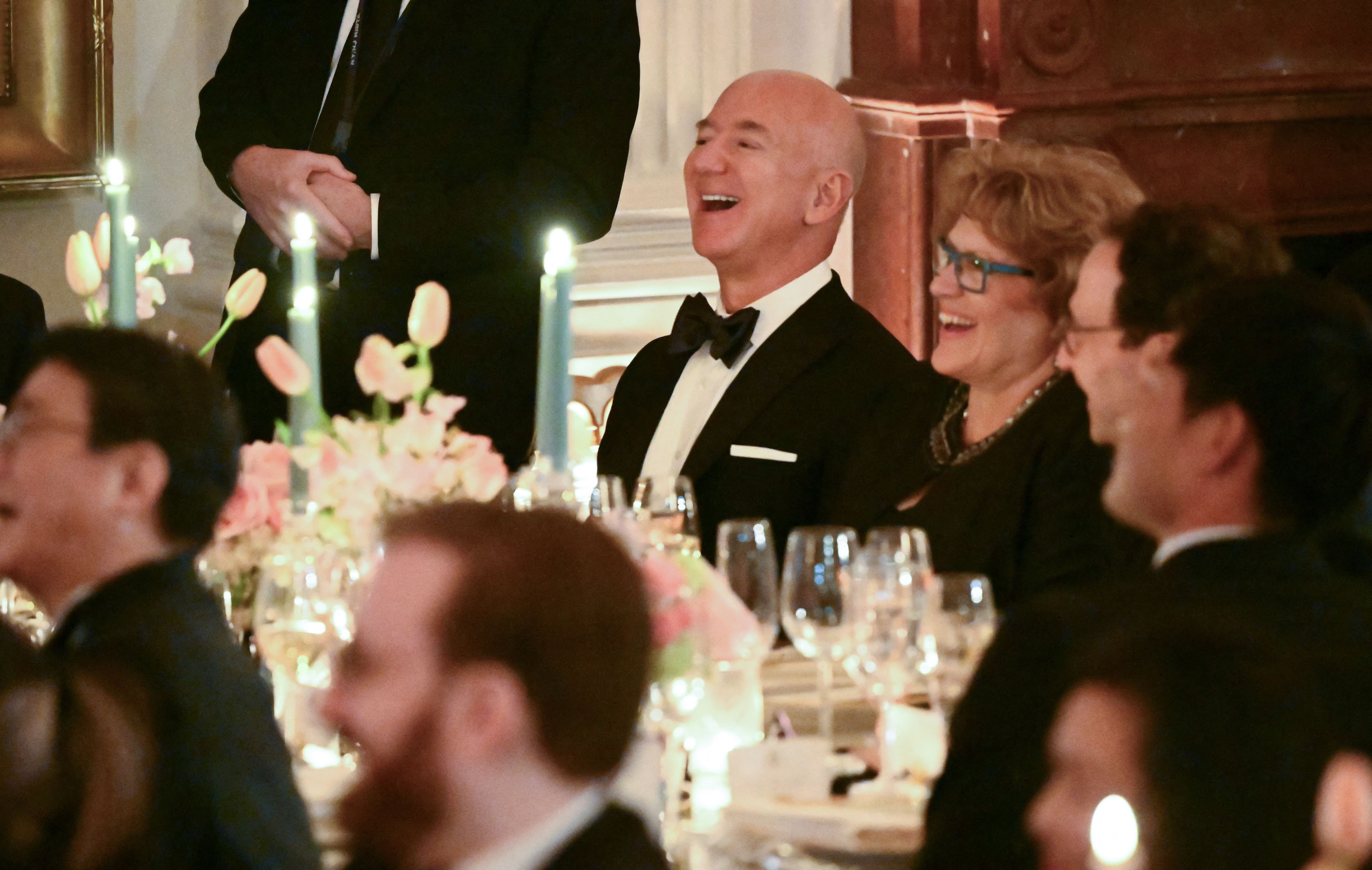 Executive chairman of Amazon Jeff Bezos laughs as he attends a State dinner for Japanese Prime Minister Fumio Kishida and his wife Yuko Kishida in the East Room of the White House in Washington, DC, April 10, 2024. 