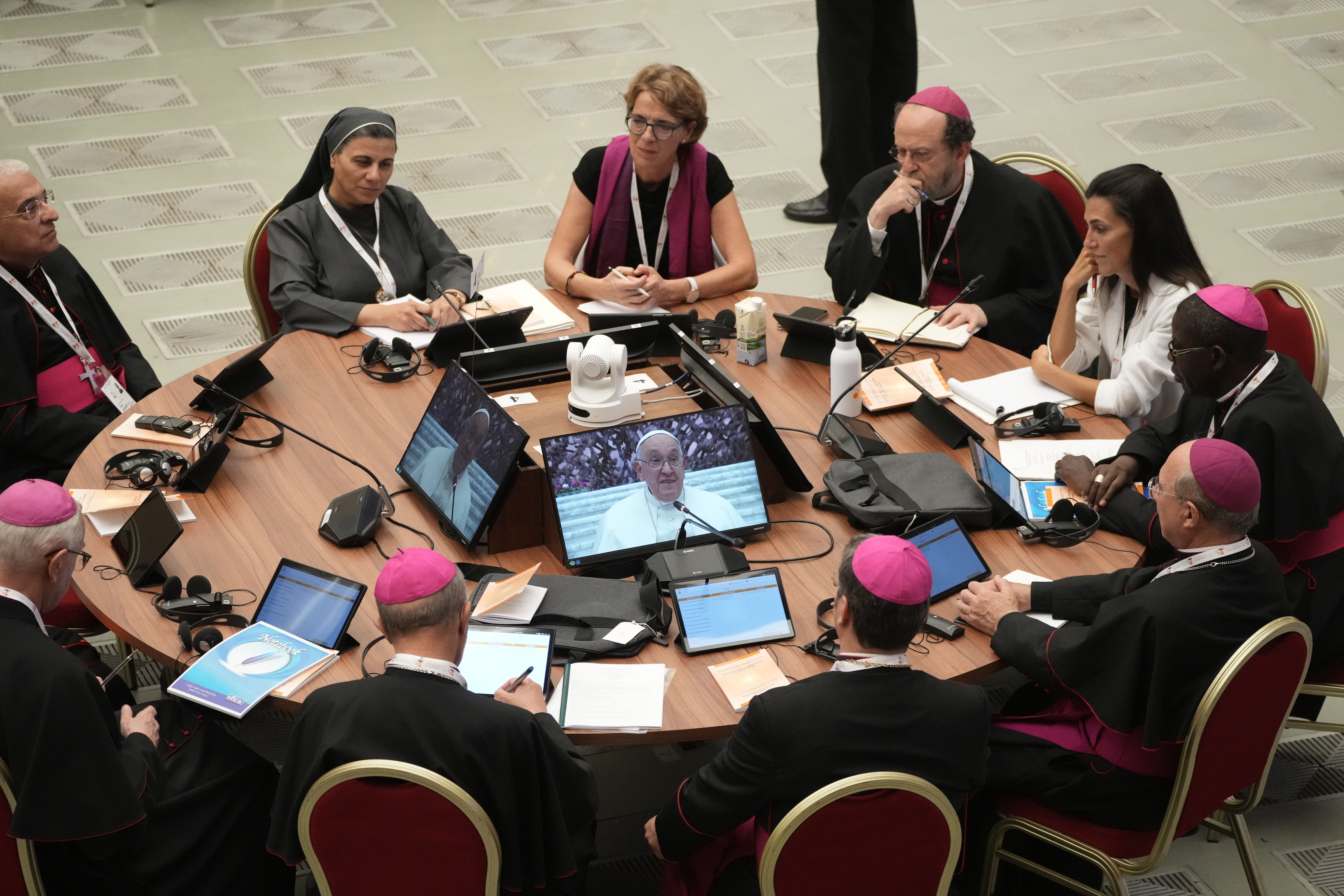 Participants in the opening session of the 16th General Assembly of the Synod of Bishops follow Pope Francis on monitors in the Paul VI Hall at The Vatican, Wednesday, Oct. 4, 2023.