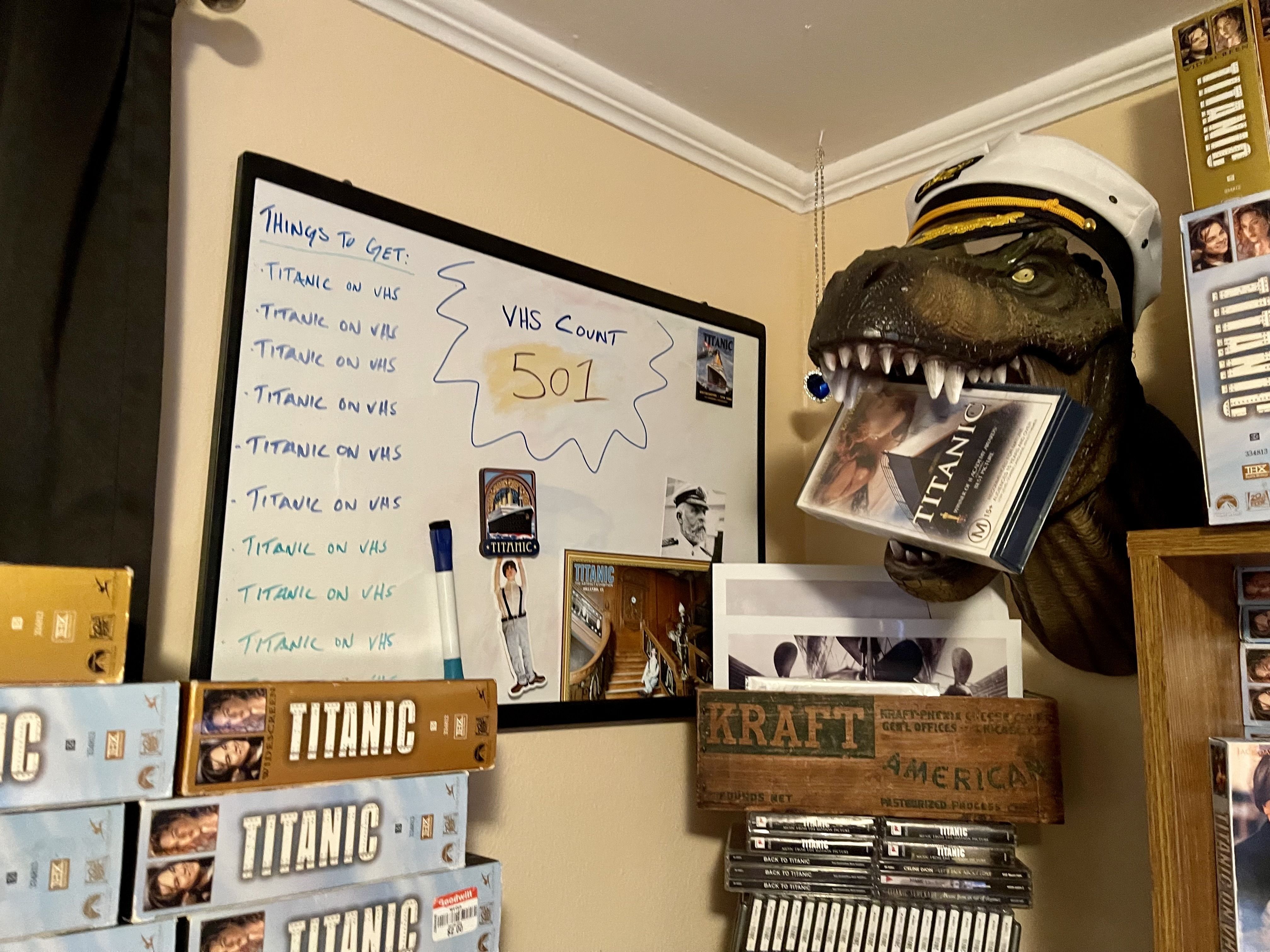 A whiteboard reading "Things to get:" with "Titanic on VHS" on the list nine times. and a VHS count reading 501