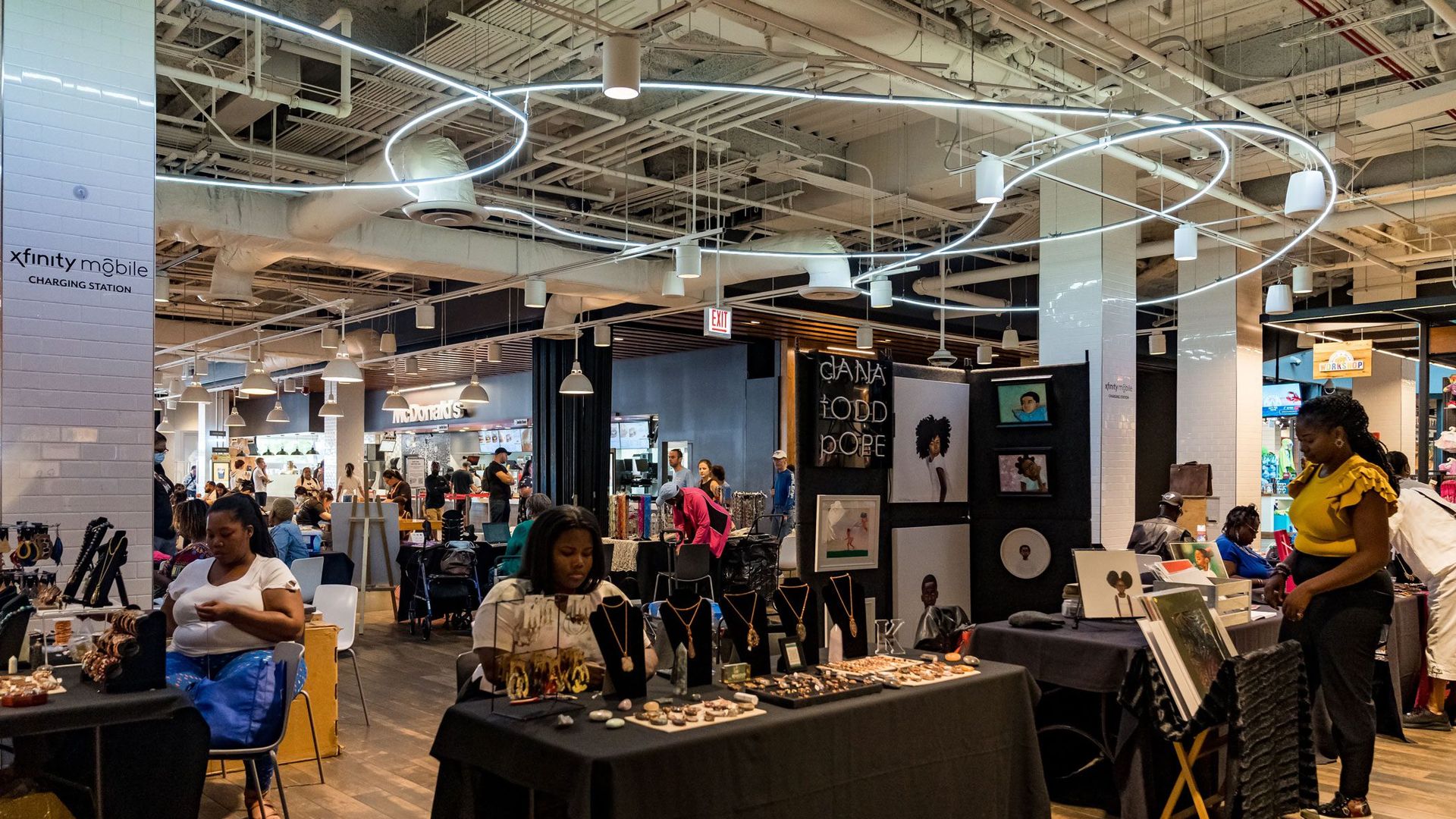 A photo showing a room full of vendors selling jewelry and art. 