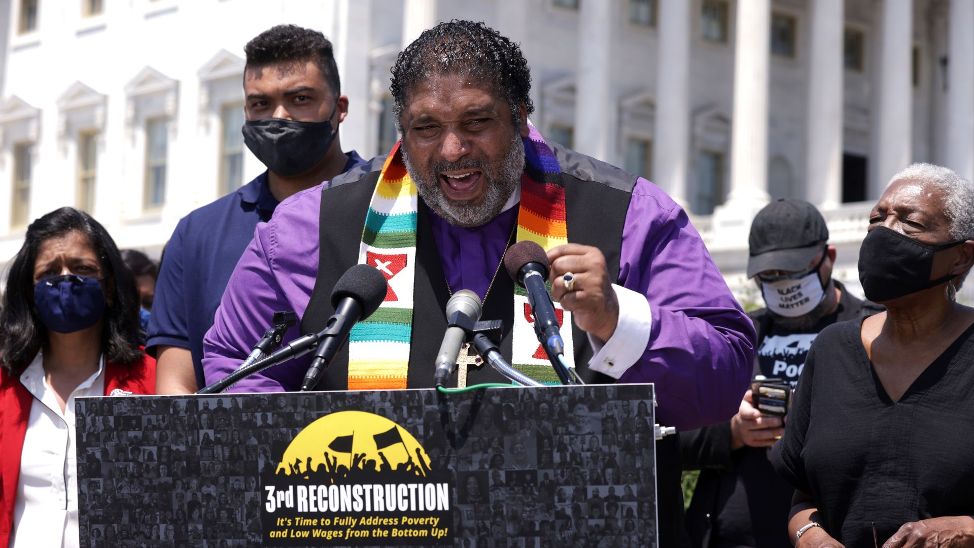 Rev. William Barber II speaks at a podium outside the U.S. Capitol in front of a sign that says 
