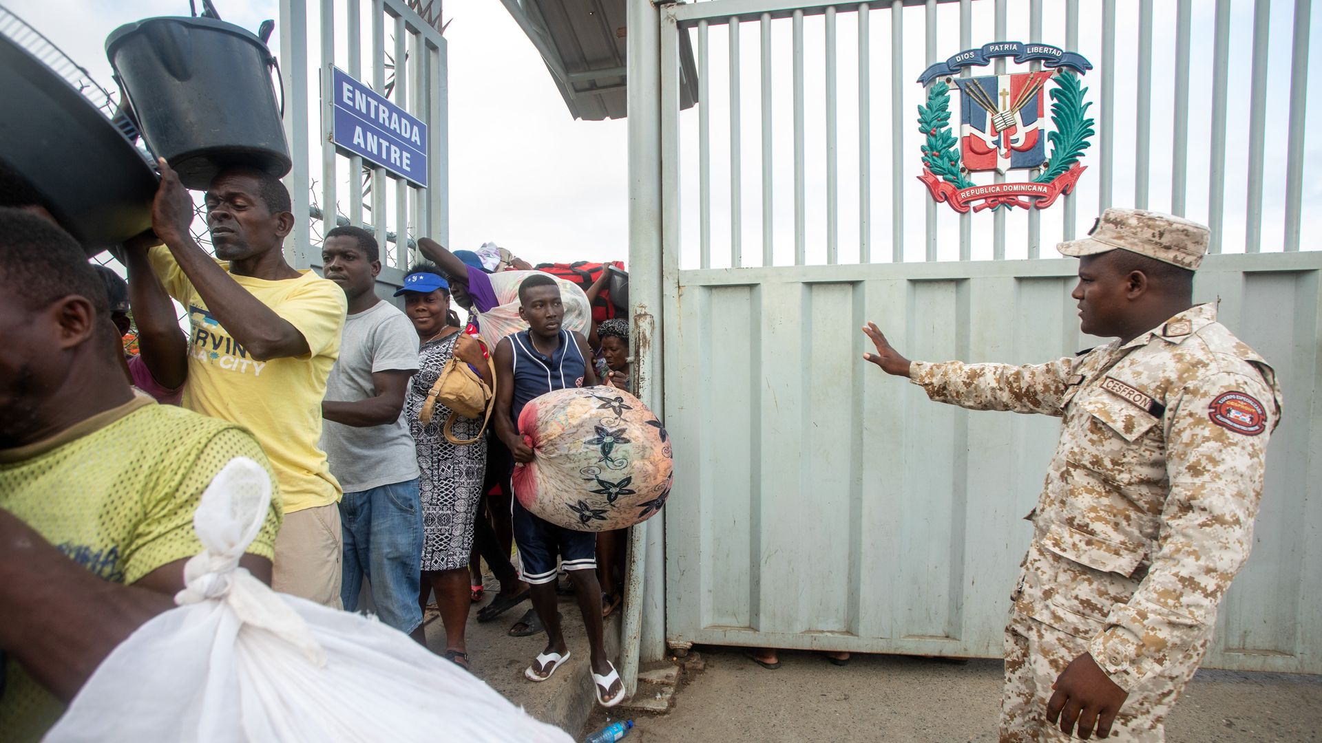 A member of the Specialized Border Security Corps (Cesfront) directs pedestrians arriving from Haiti at the Dajabon and Ouanaminthe border bridge entry gate in Dajabon, Dominican Republic.