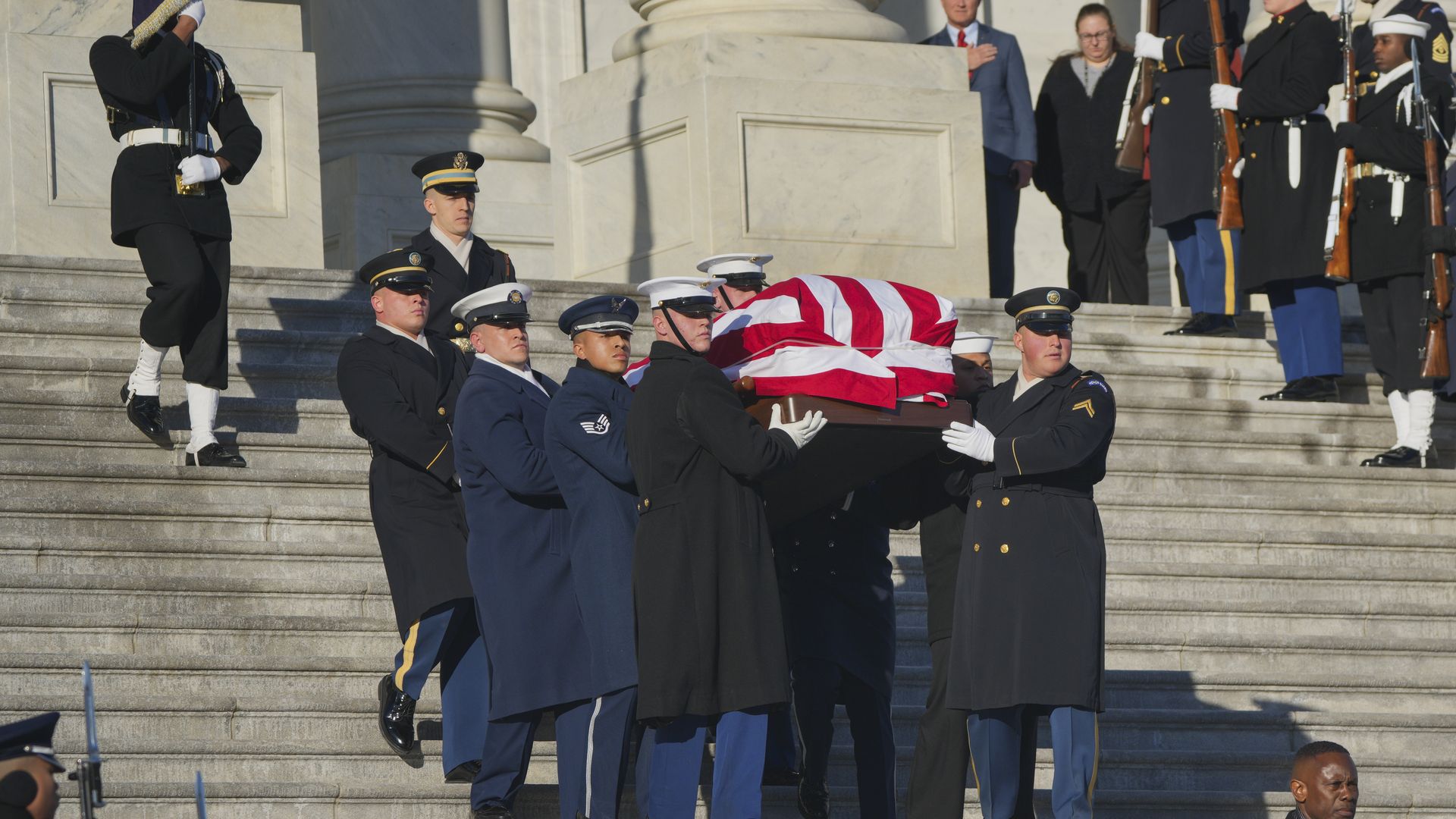 The flag-draped casket of former U.S. President Jimmy Carter is carried by a joint services military honor guard down the steps of the U.S. Capitol on January 9, 2025