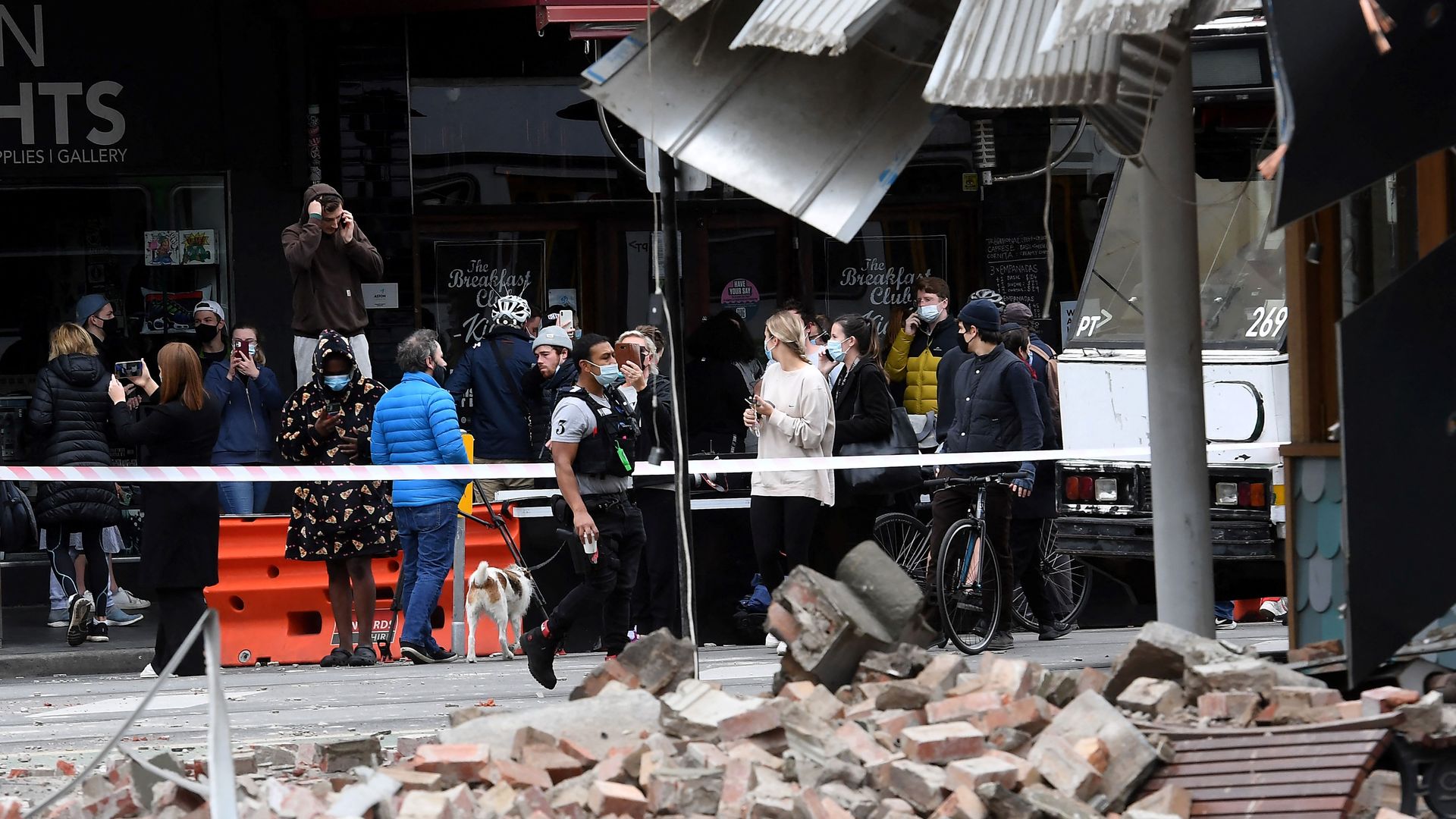  Residents and media gather near a damaged building in the popular shopping Chappel Street in Melbourne on September 22, 2021, after a 5.9 magnitude earthquake.