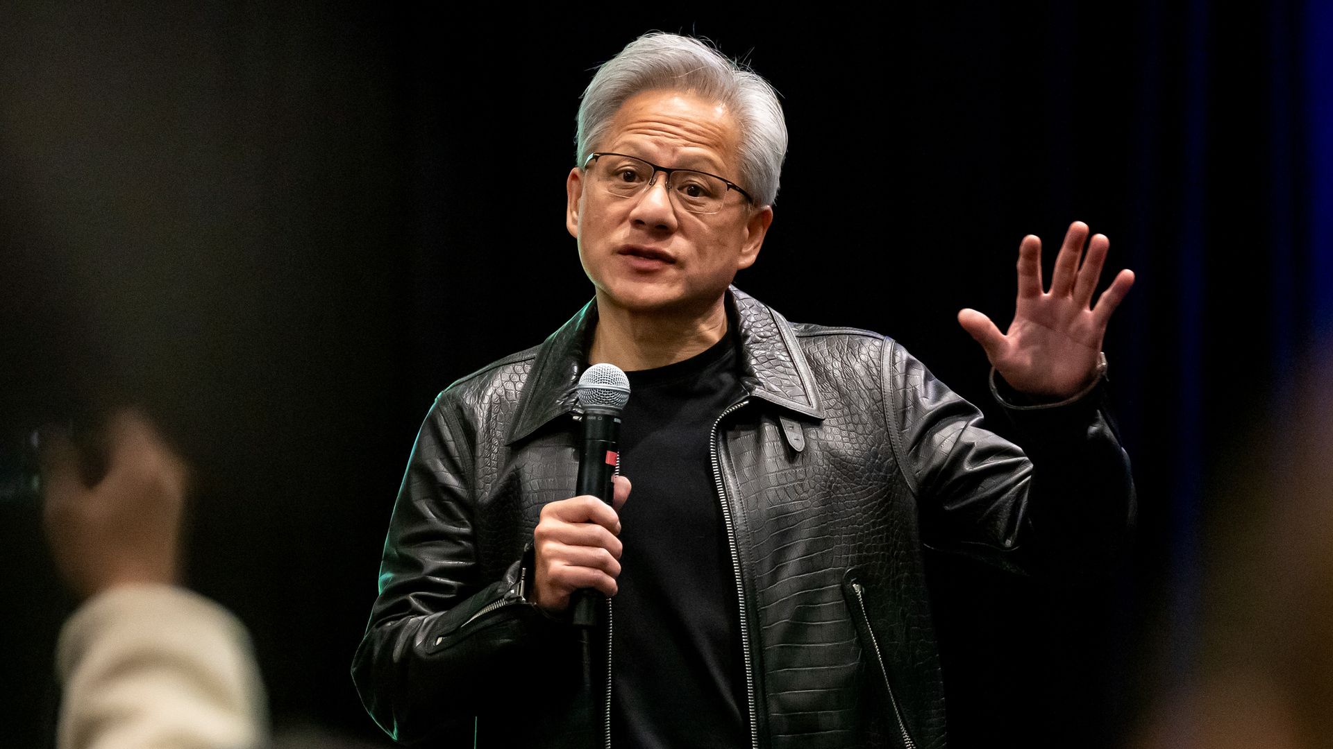 Jensen Huang at a podium during Nvidia’s 2025 GTC conference in San Jose, addressing an audience.