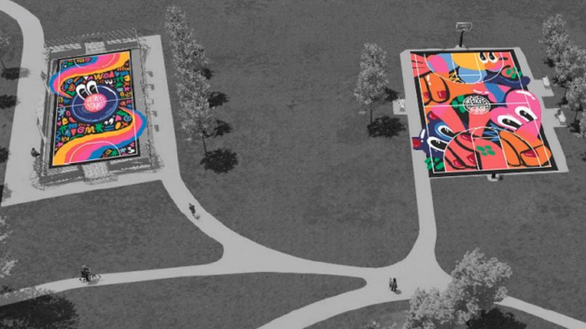 An aerial view of a park showing two large, colorful abstract murals on rectangular platforms; grayscale paths and grass, with a cyclist on the left, two pedestrians, and trees.