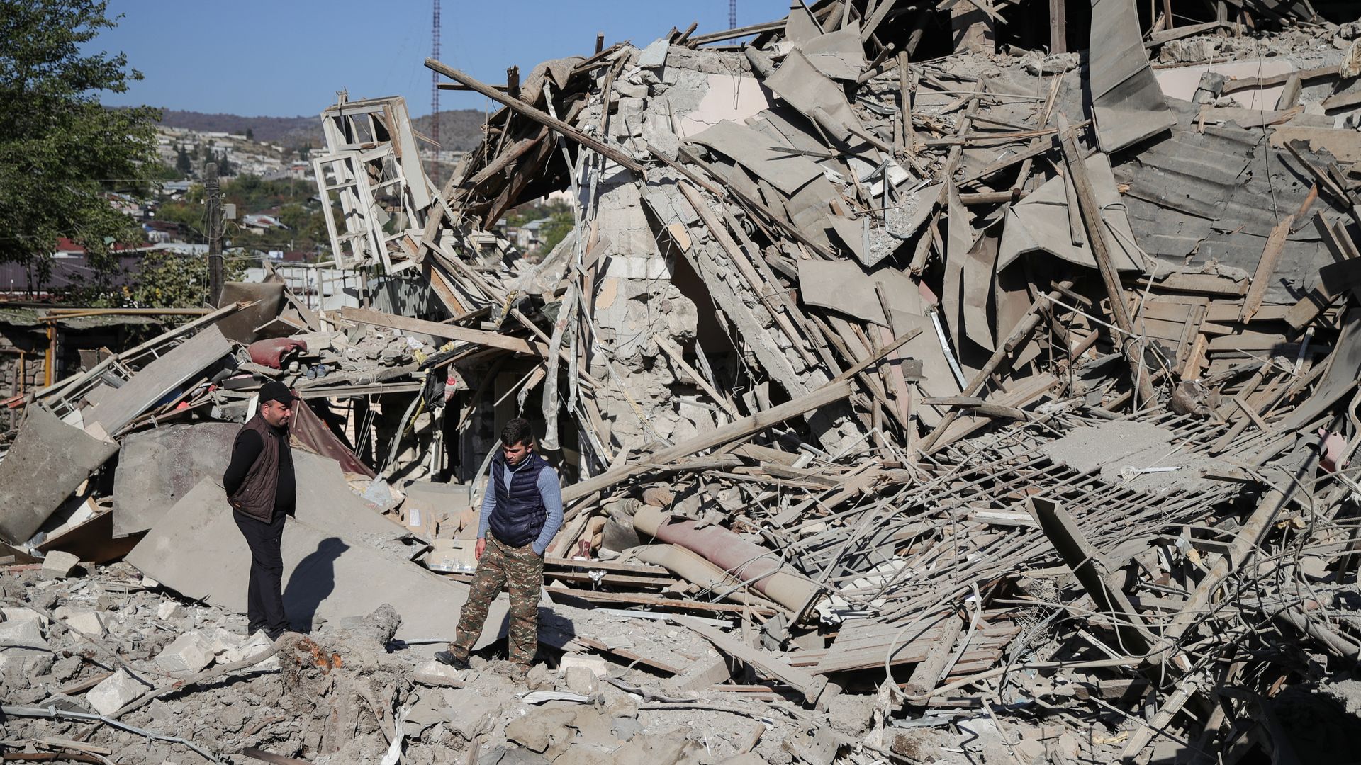 Local residents by the ruins of a residential house destroyed in a night shelling attack.