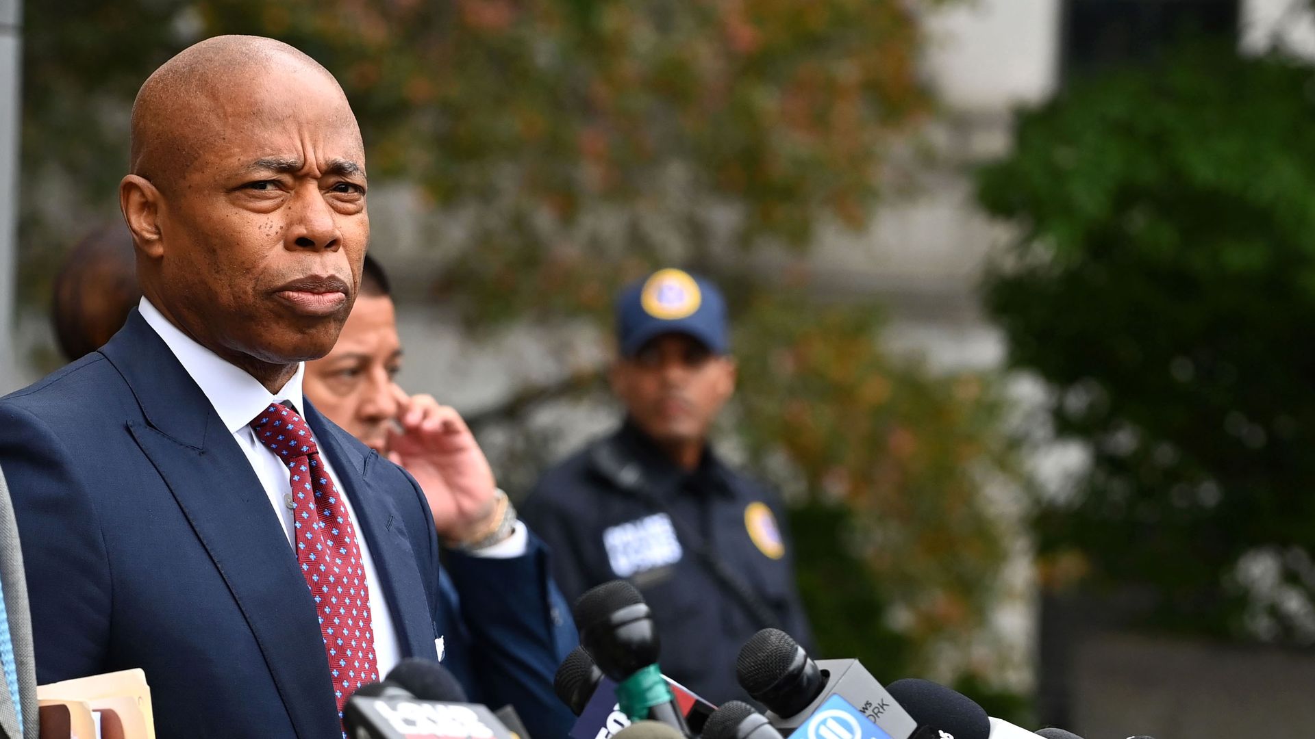Eric Adams stands in front of microphones after exiting the court house 