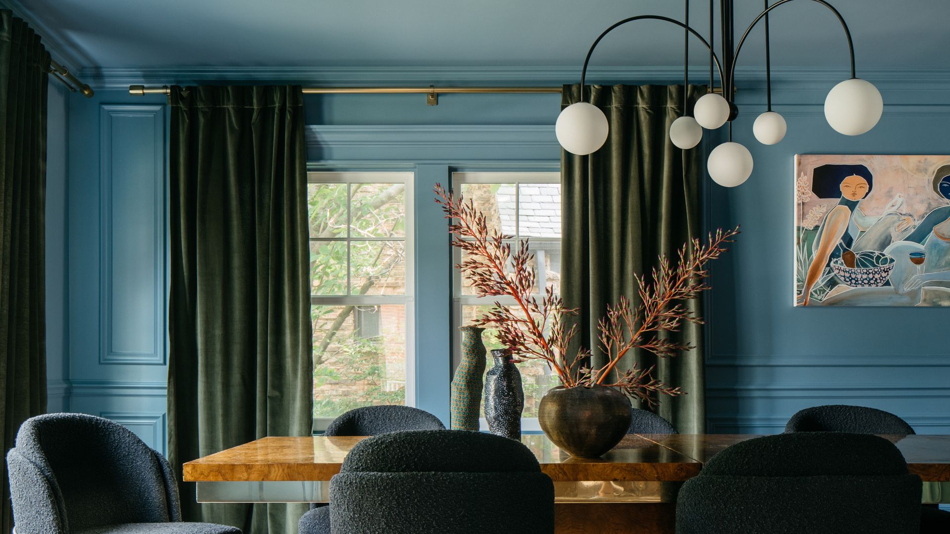 blue dining room with large table and artwork